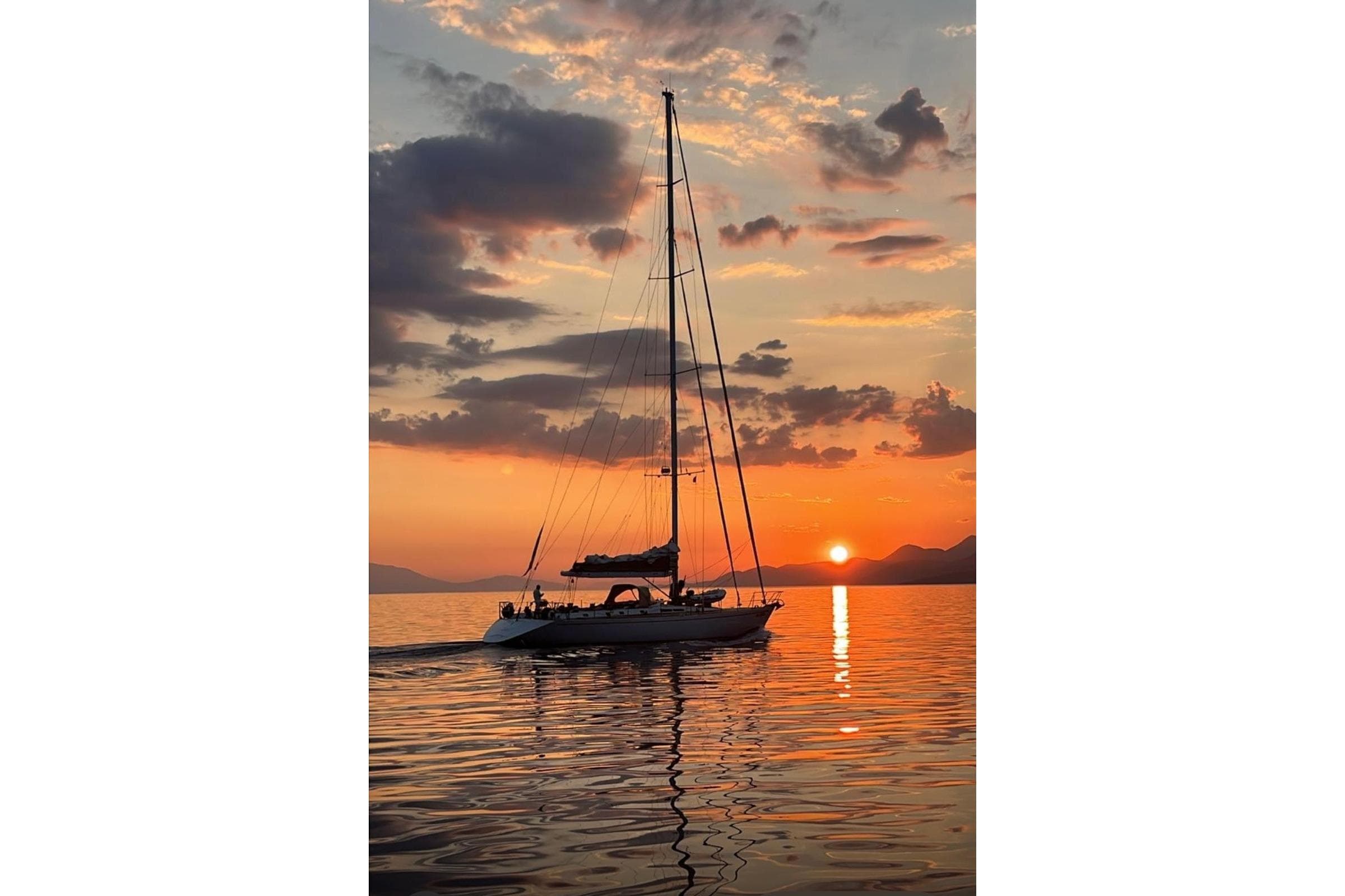 Sailing yacht De Cesari Vallicelli 72 at sunset, 1991 model, serene ocean view.