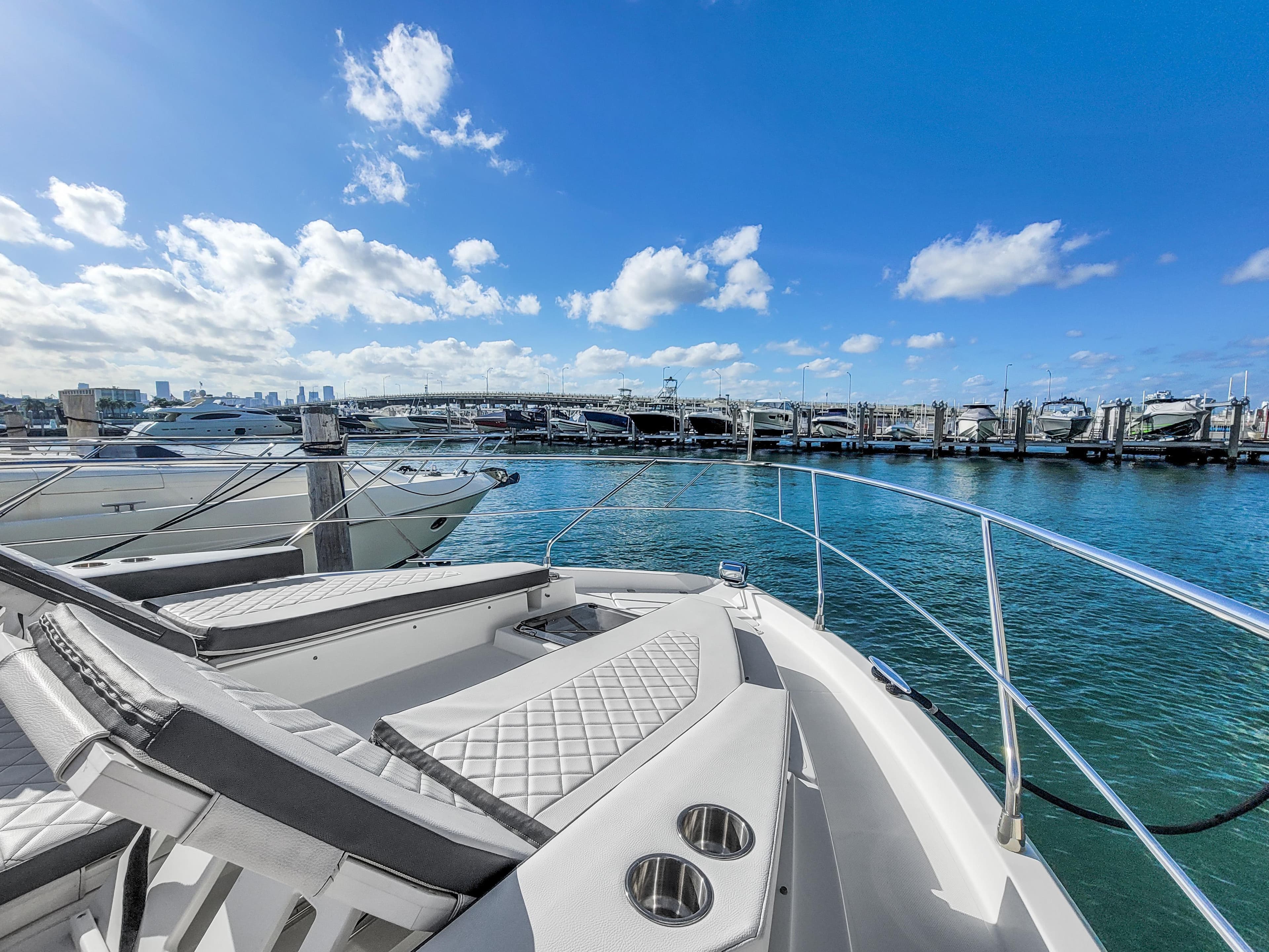 2019 Cruisers 50 Cantius yacht docked at a marina with a clear blue sky.