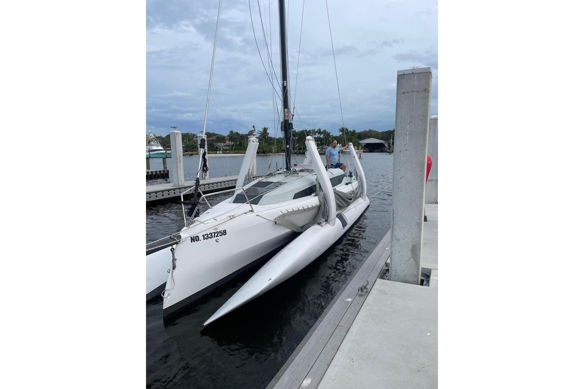 2021 Corsair 880 Sport trimaran docked at a marina under cloudy skies.
