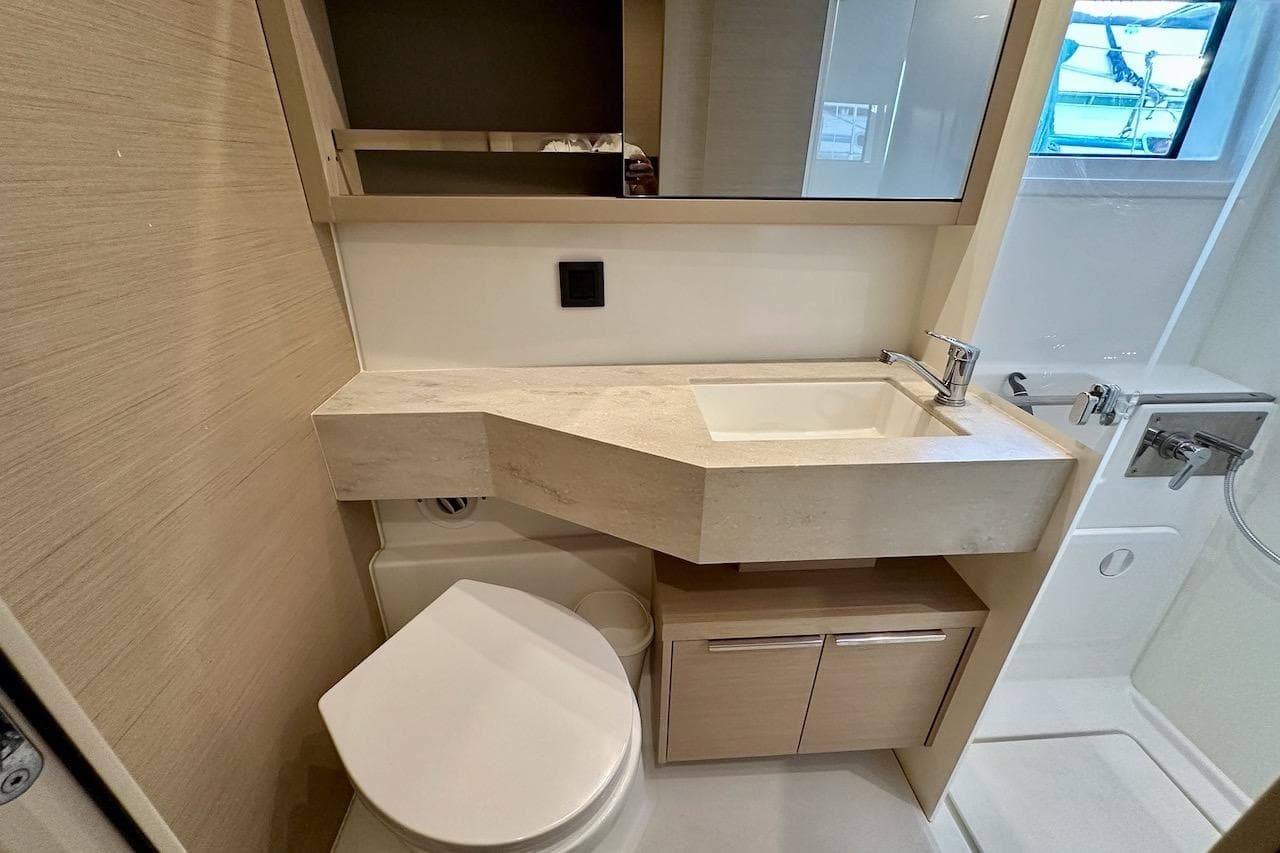 Modern bathroom in 2023 Lagoon 46 yacht with sleek sink and compact toilet design.