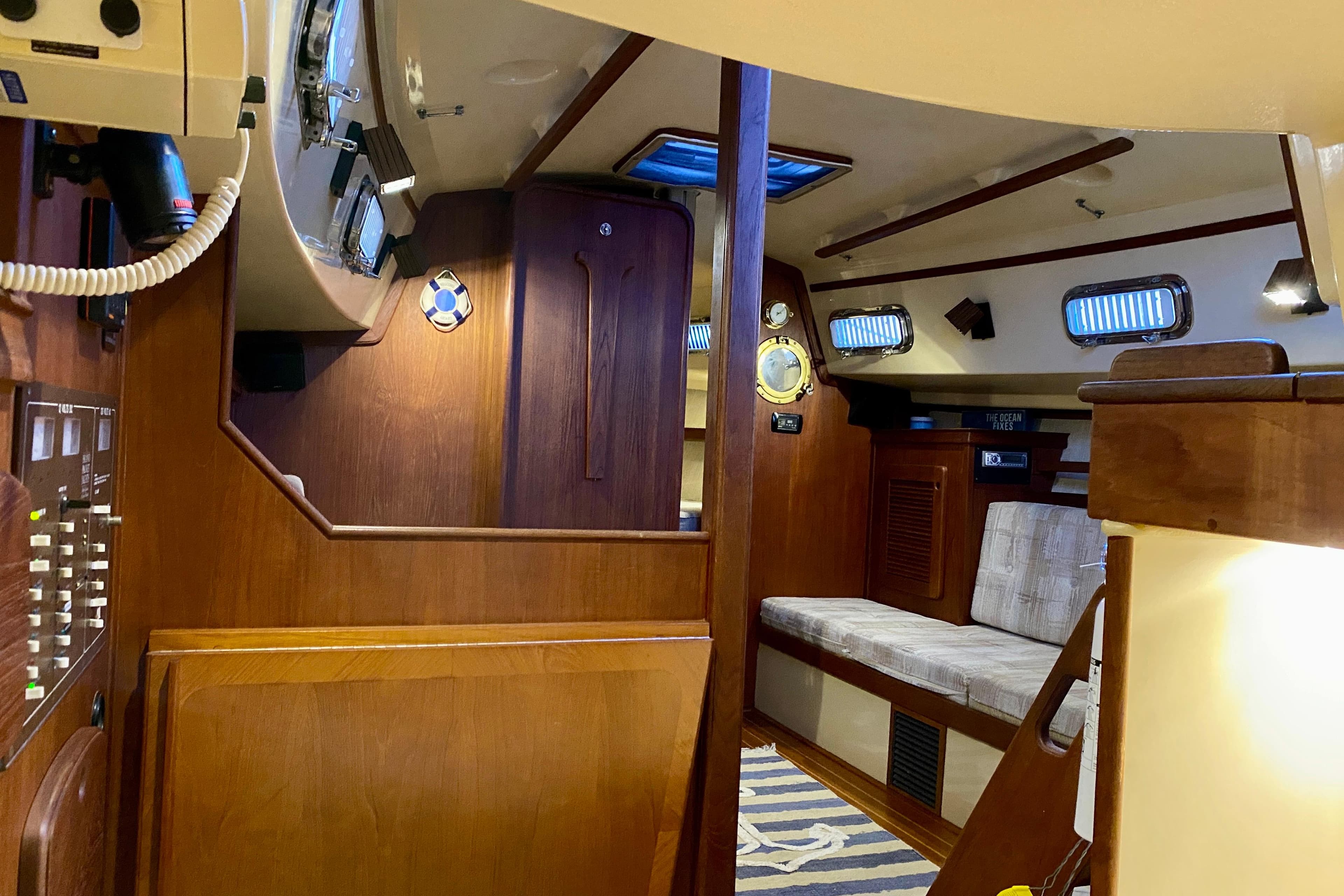 1992 Island Packet 29 sailboat interior with wood paneling and seating area.