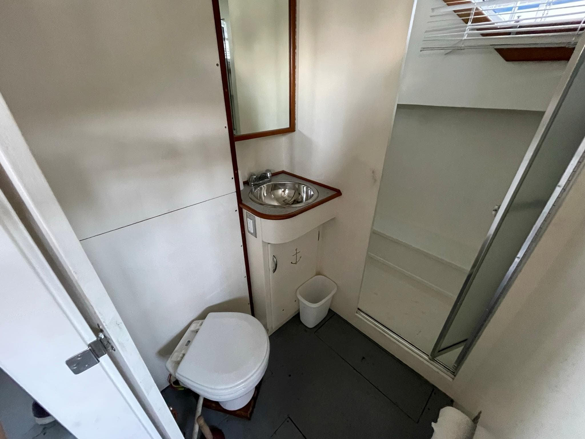 1961 Chris-Craft Conqueror bathroom with sink, toilet, and shower.