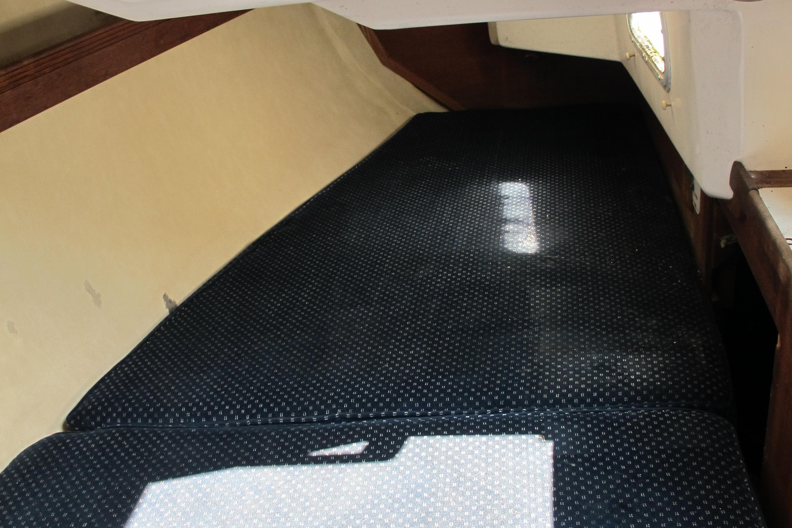 Interior cabin of 1987 Sabre 34 sailboat with dark cushioned seating.