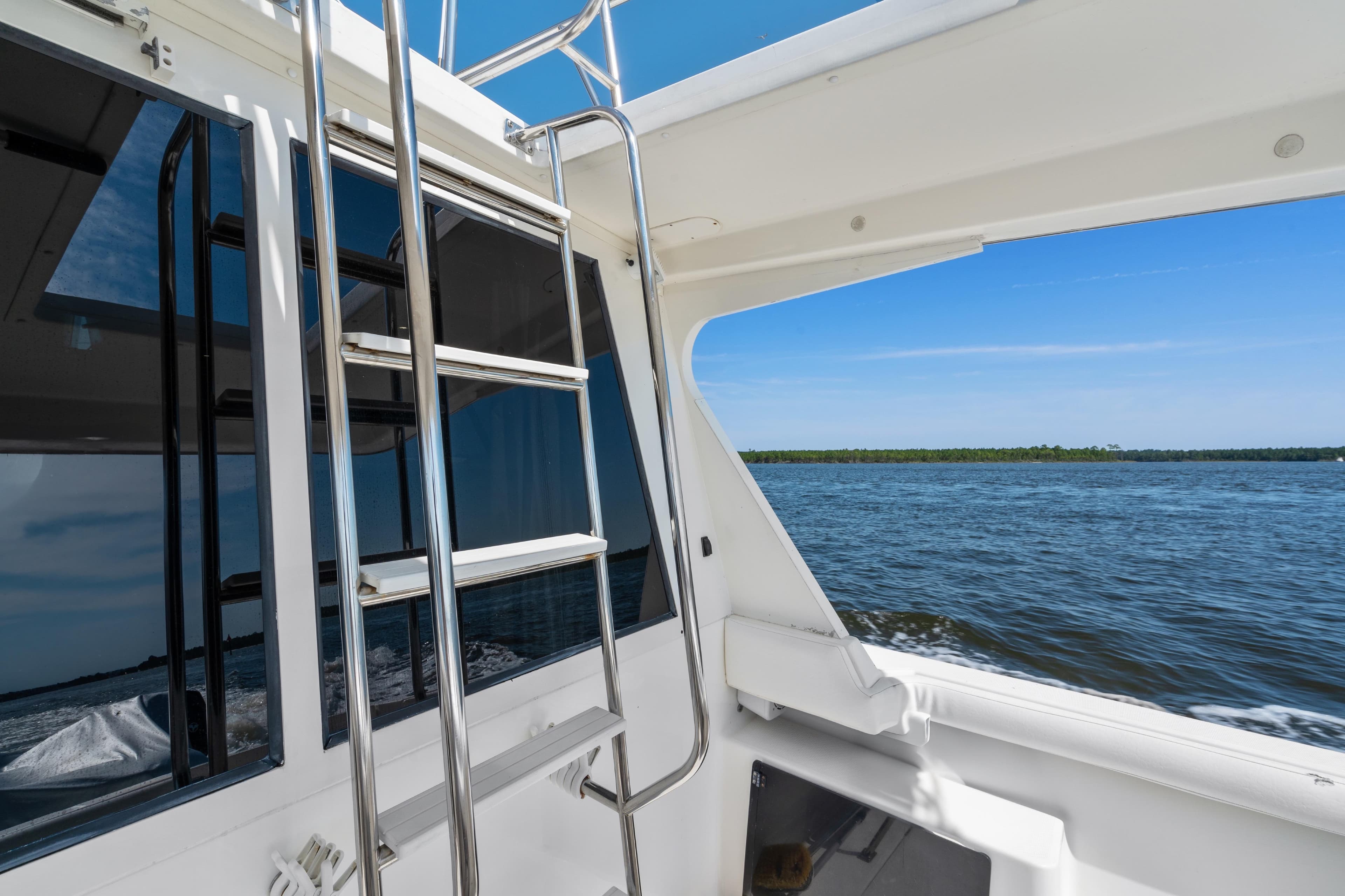 2007 Meridian 490 Pilothouse yacht with ladder, cruising on open water.