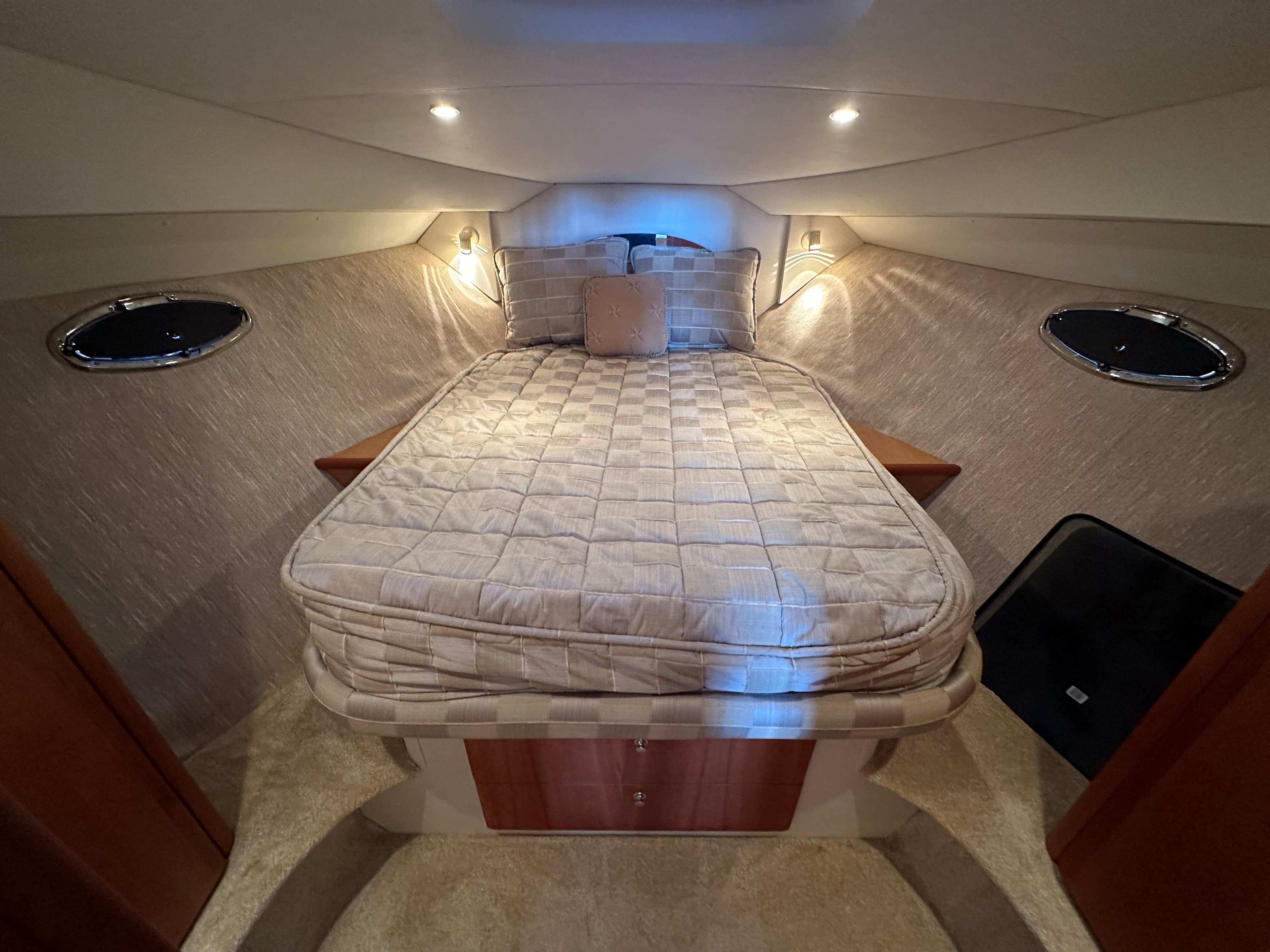 Cozy bedroom in 2002 Silverton 35 Convertible yacht with elegant lighting and plush bedding.