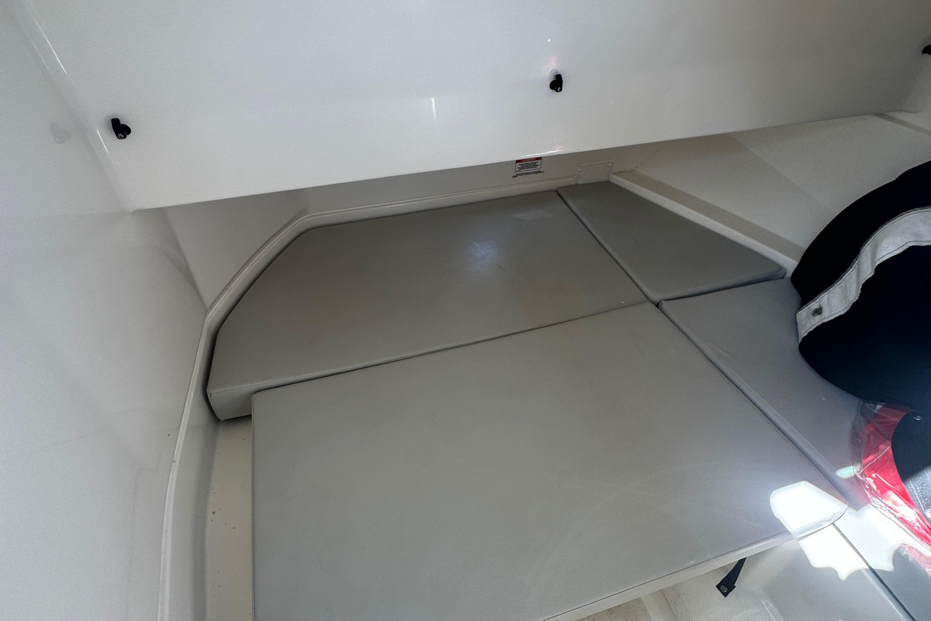 2025 Sea Ray SDX 250 Outboard interior cabin with cushioned seating area.