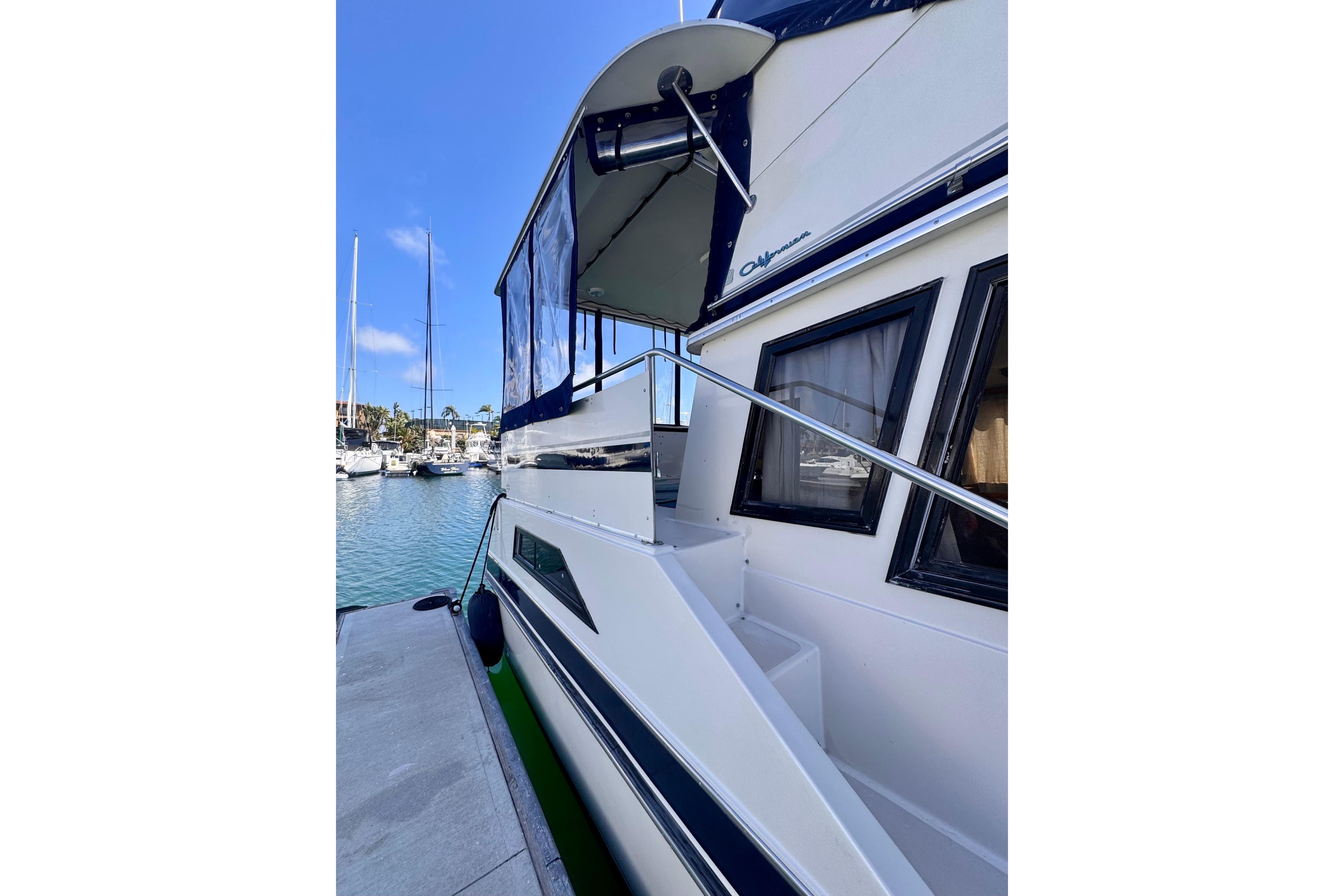 1985 Californian 35 Motor Yacht docked at marina, showcasing sleek design and spacious deck.