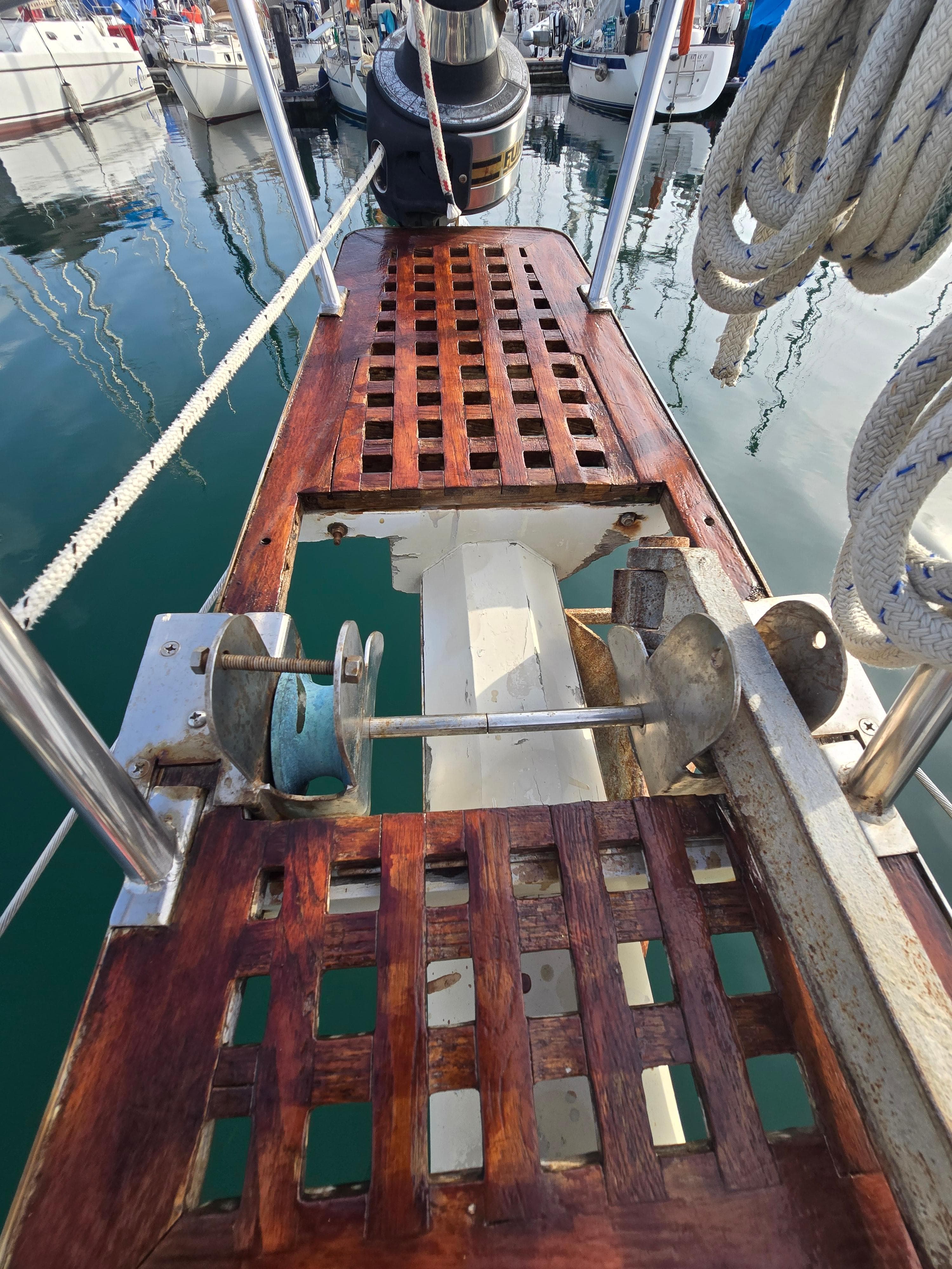 1981 Tayana 37 Pilothouse deck with wooden grating and nautical equipment in a marina.