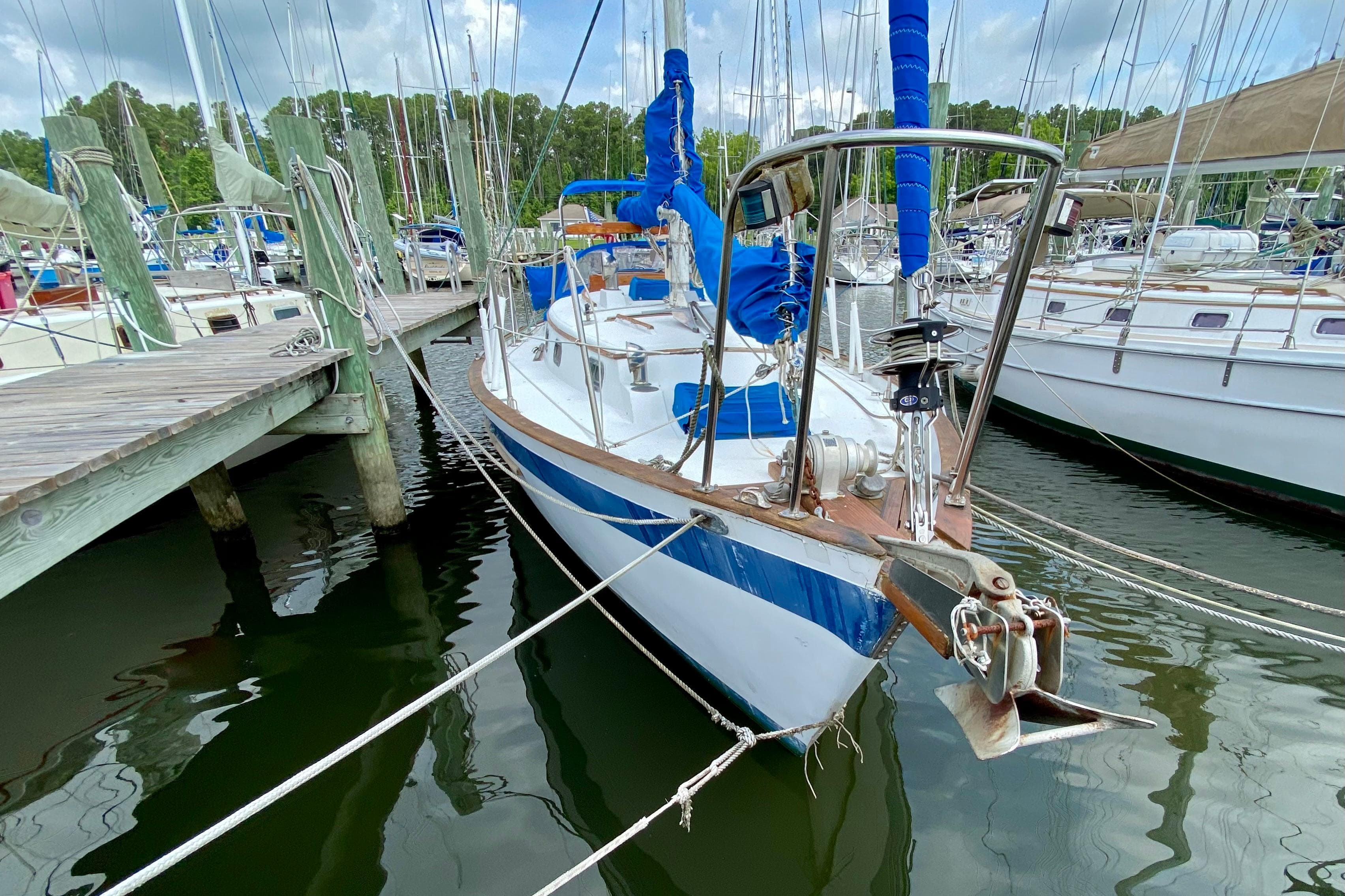 Sailboat docked at marina, Union EO 32 model, 1981, with blue accents and rigging.