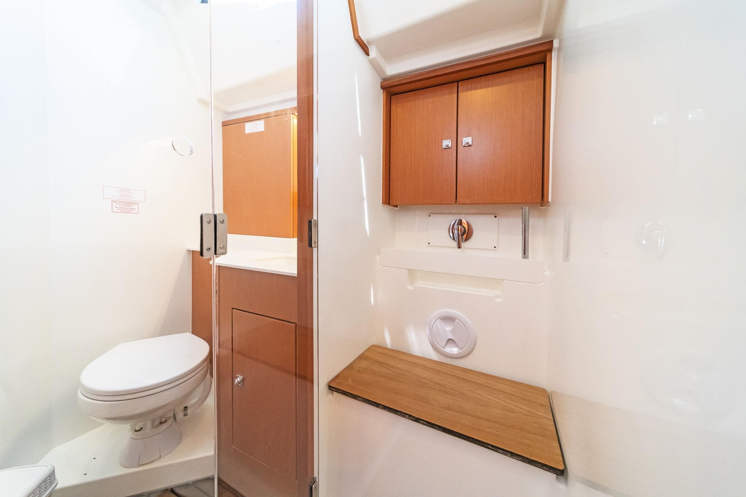 2021 Bavaria C57 Style yacht bathroom with wooden cabinets and modern fixtures.