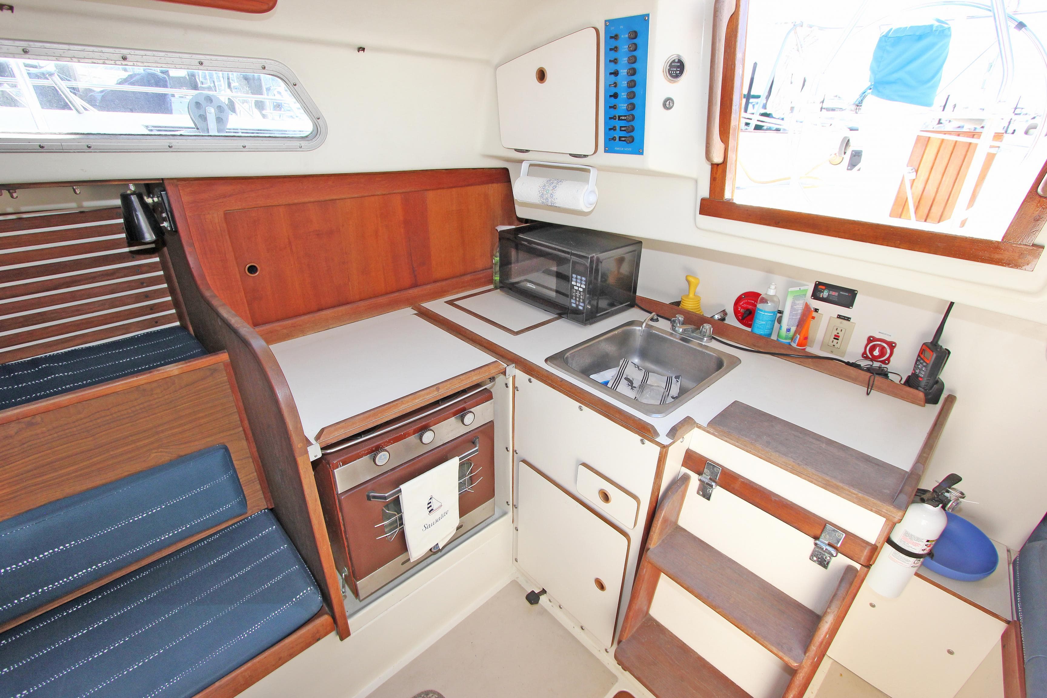 1977 Pearson 10M sailboat galley with stove, sink, and storage cabinets.