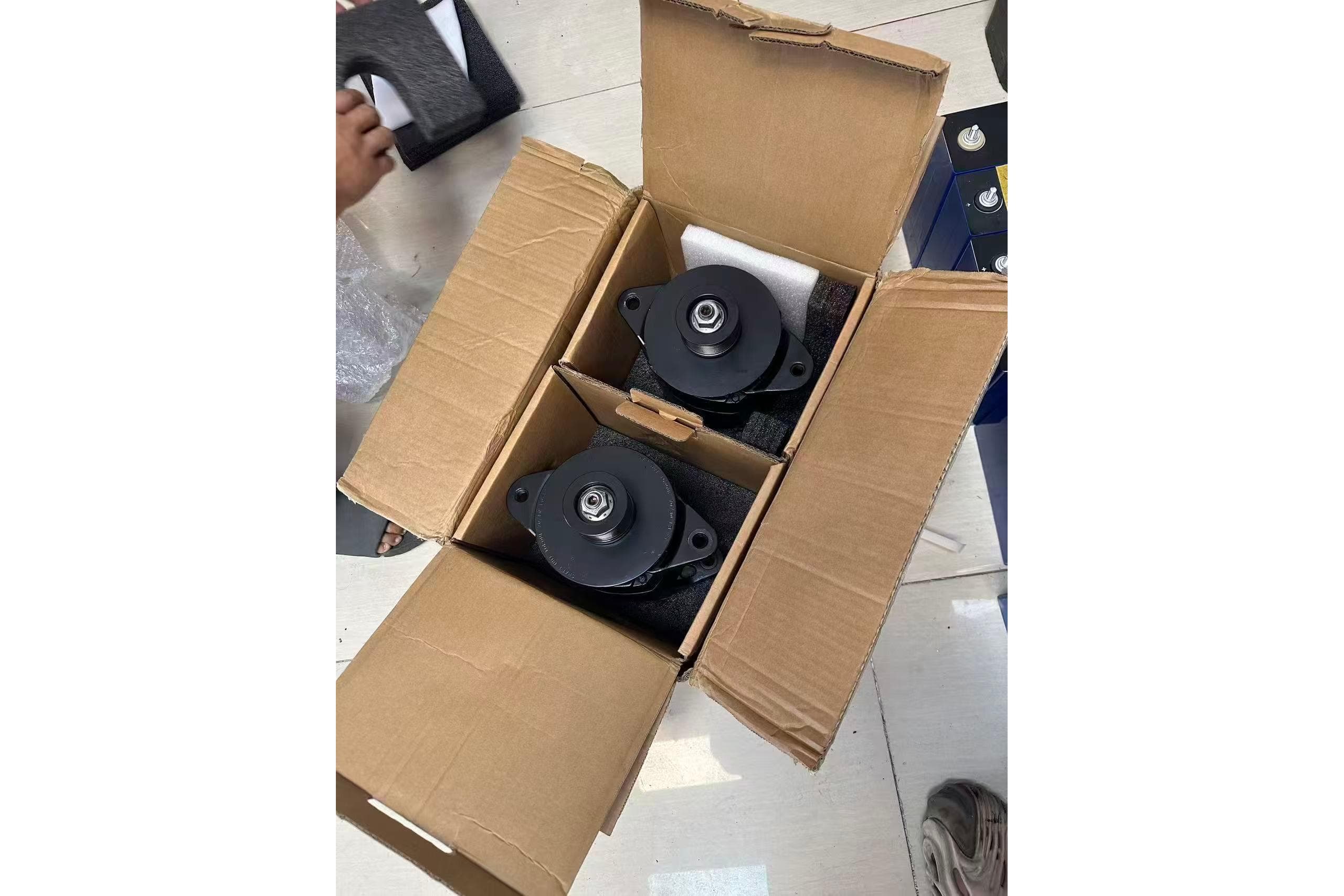 Cardboard box with two black mechanical parts, possibly for Catana 47, 2011 model.