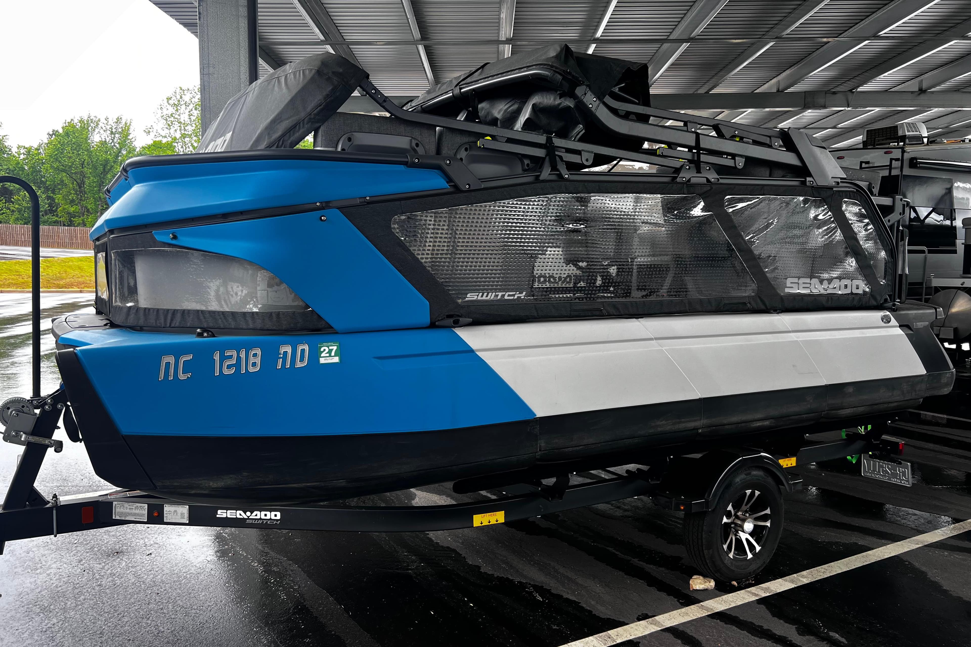 2023 Sea-Doo Switch Cruise 18 boat on trailer, parked under shelter.