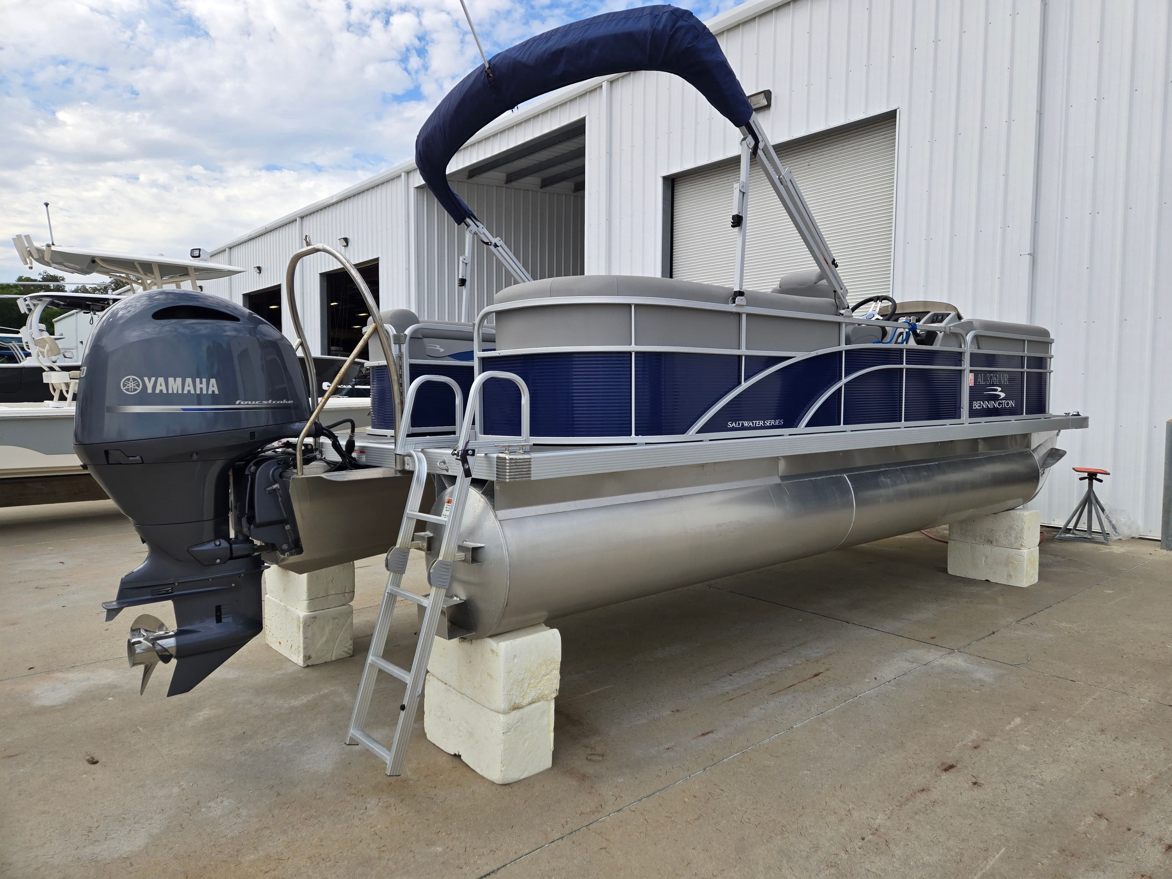 2022 Bennington 22SVSRST pontoon boat with Yamaha motor, stored on concrete blocks.