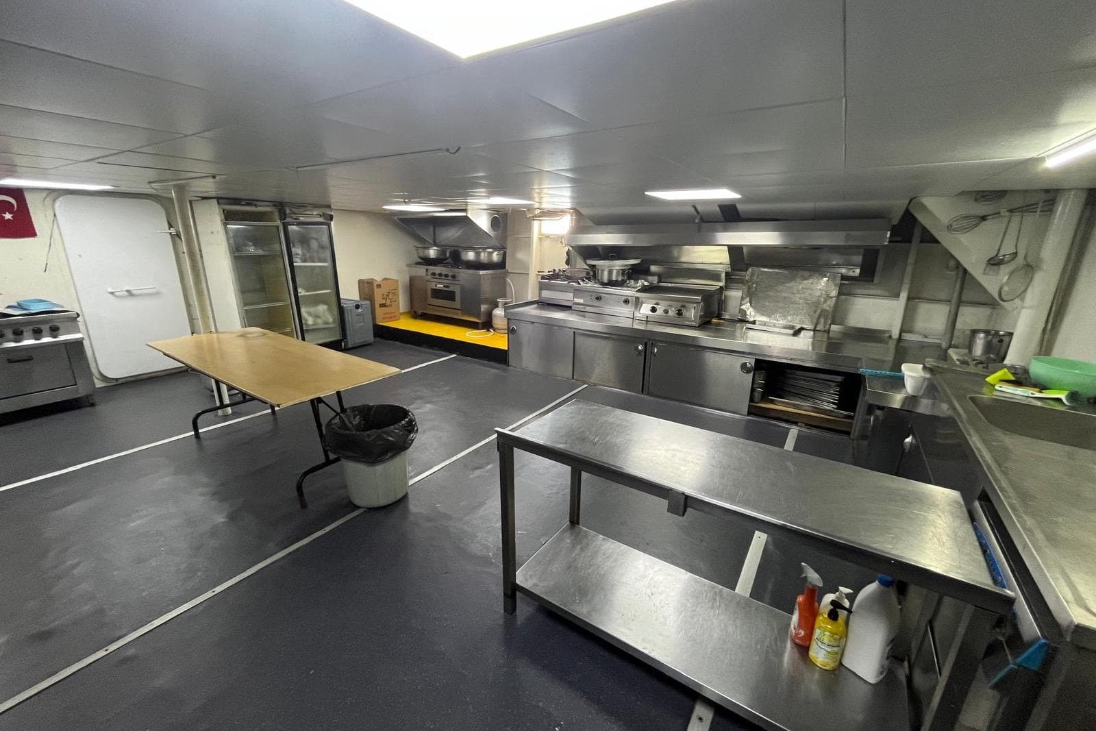 Spacious commercial kitchen on a 2011 Custom-Craft restaurant vessel, featuring stainless steel appliances.