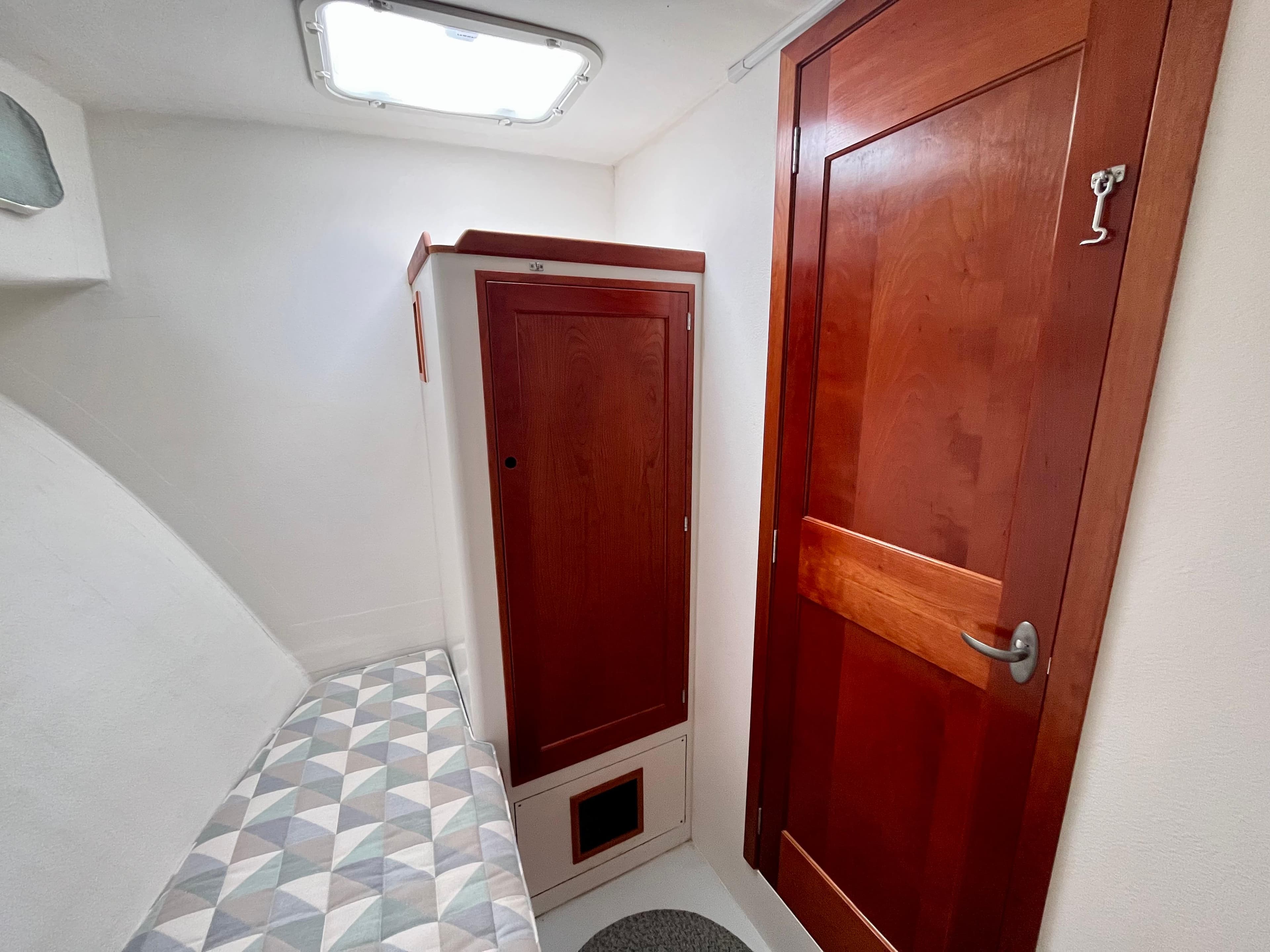 Cozy cabin interior of 2016 Wesmac 42 with wooden door and storage.