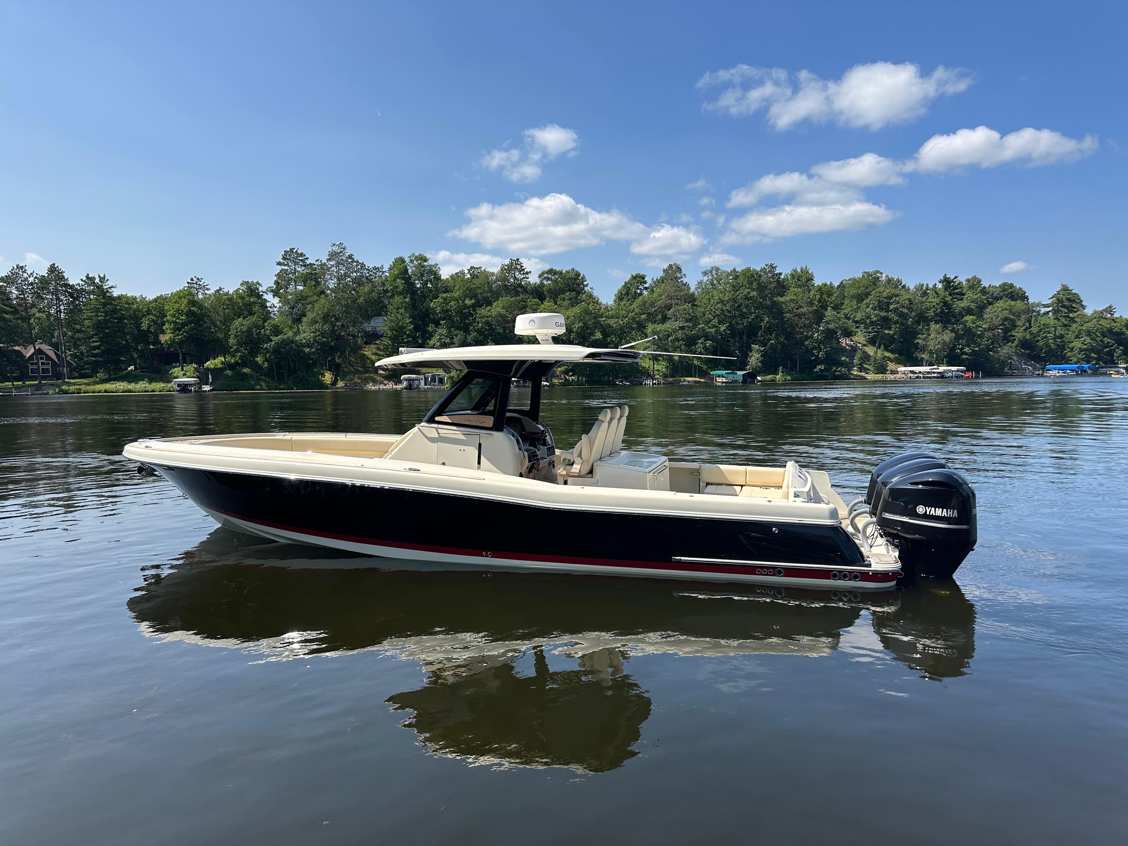 2019 Chris-Craft Catalina 34 boat on a calm lake with a forested shoreline.