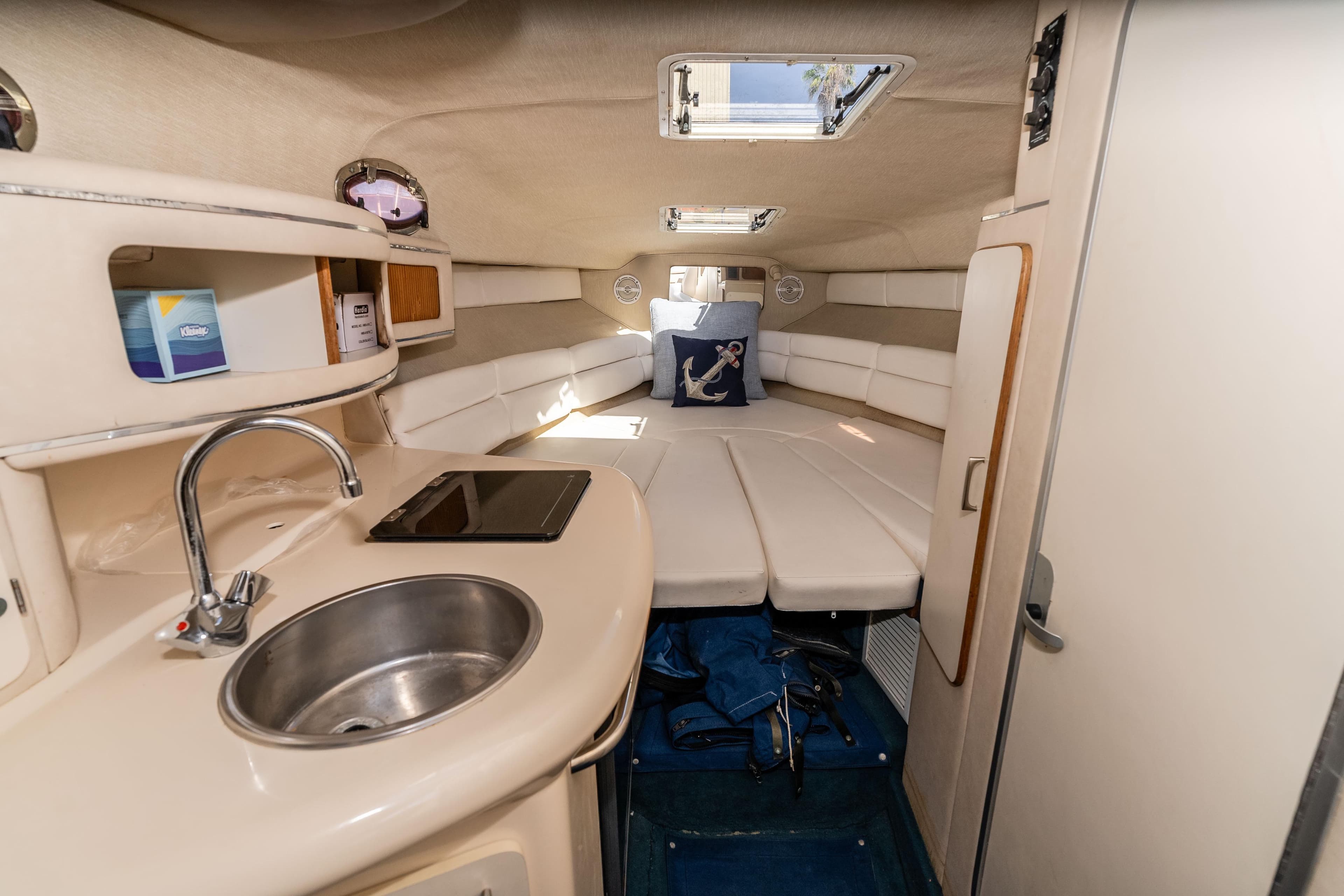 1995 Sea Ray 270 Sundancer cabin interior with kitchenette and cozy seating area.