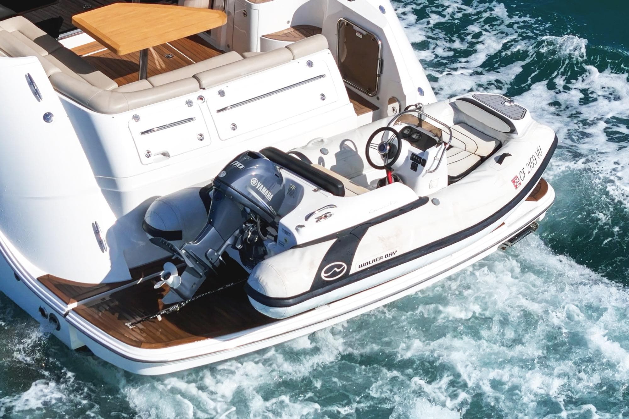 2018 Sea Ray Fly 510 yacht with a Walker Bay tender on the water.