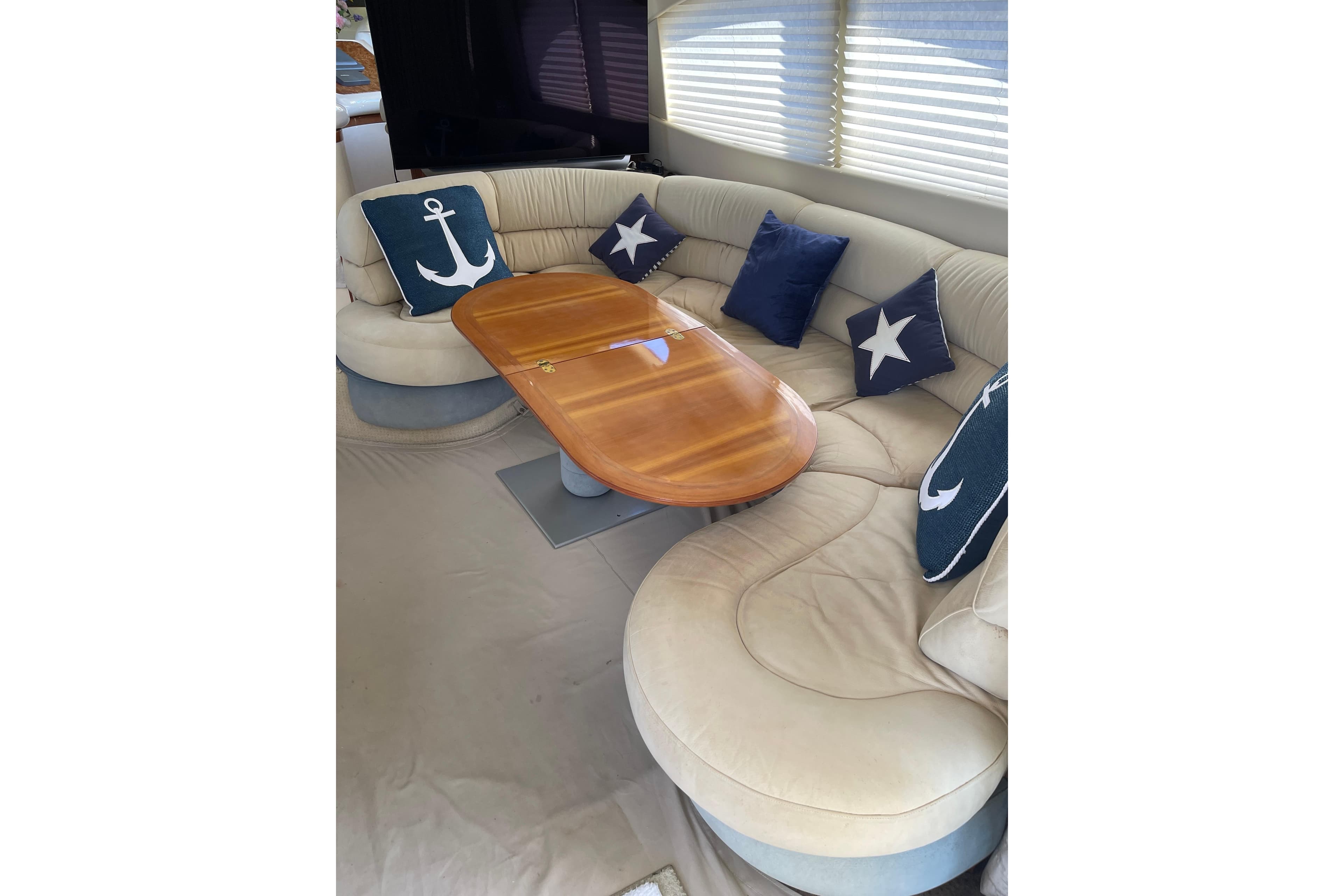 Luxurious interior of 2000 Azimut 46 Flybridge MY with elegant seating and nautical-themed cushions.