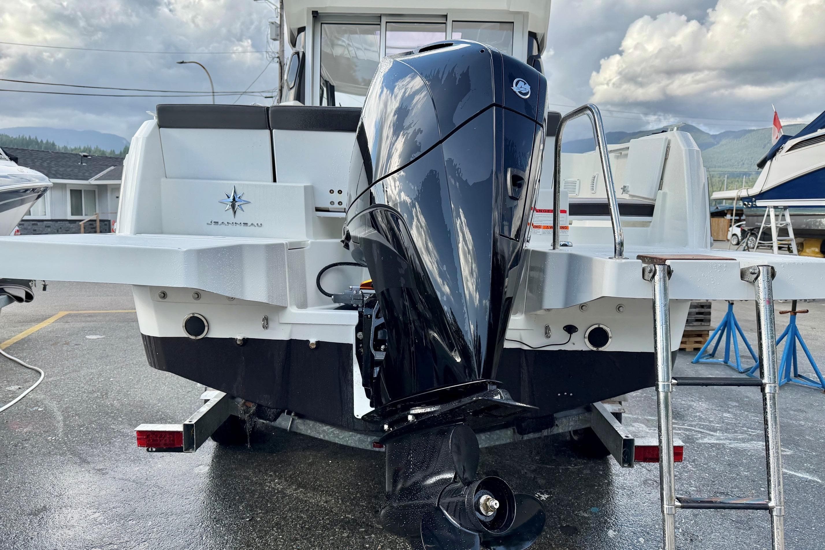 2023 Jeanneau NC Sport 695 Series 2 boat with powerful outboard motor, docked outdoors.