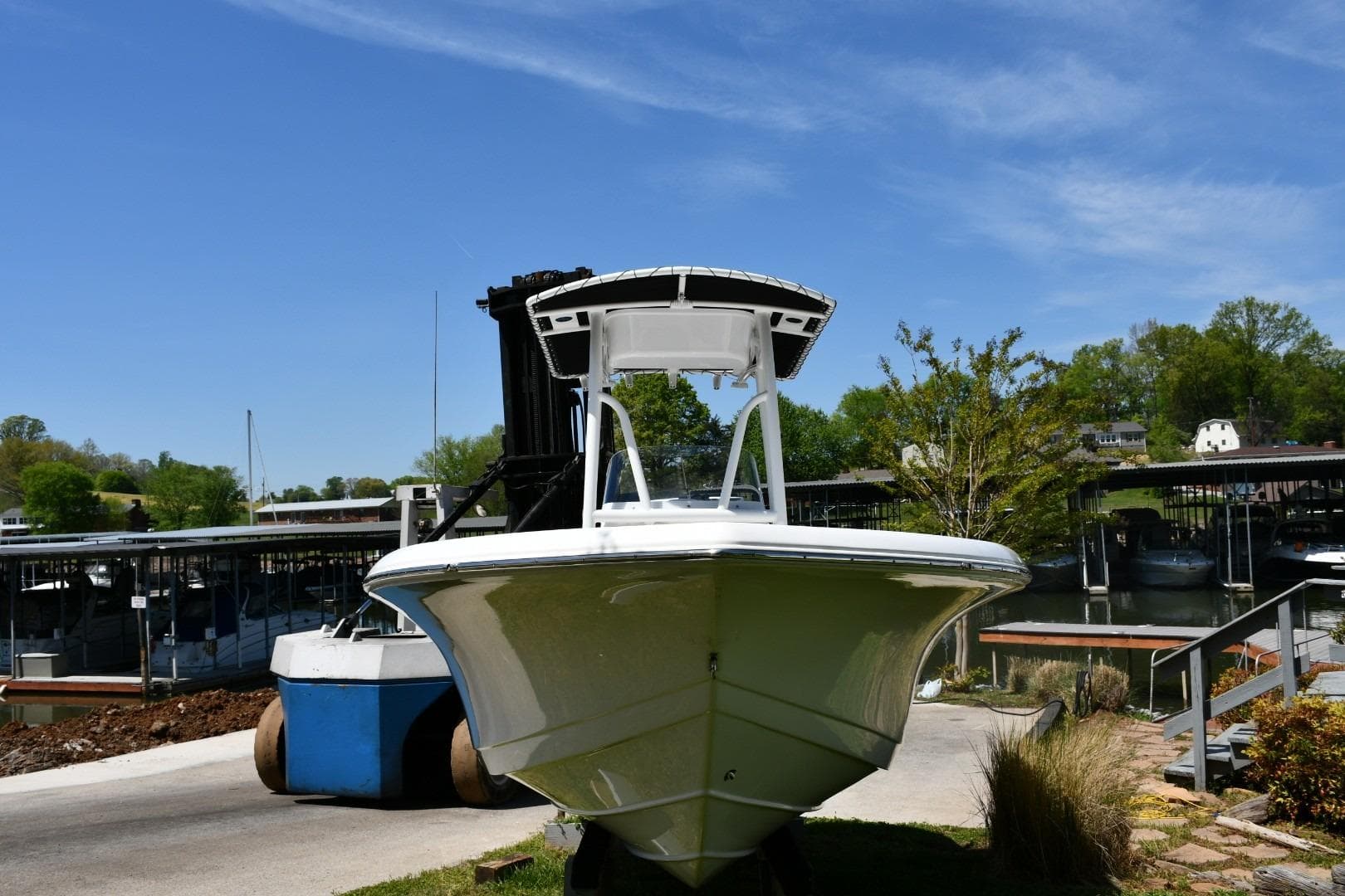 2023 Tidewater 210 LXF boat docked at a marina under a clear blue sky.