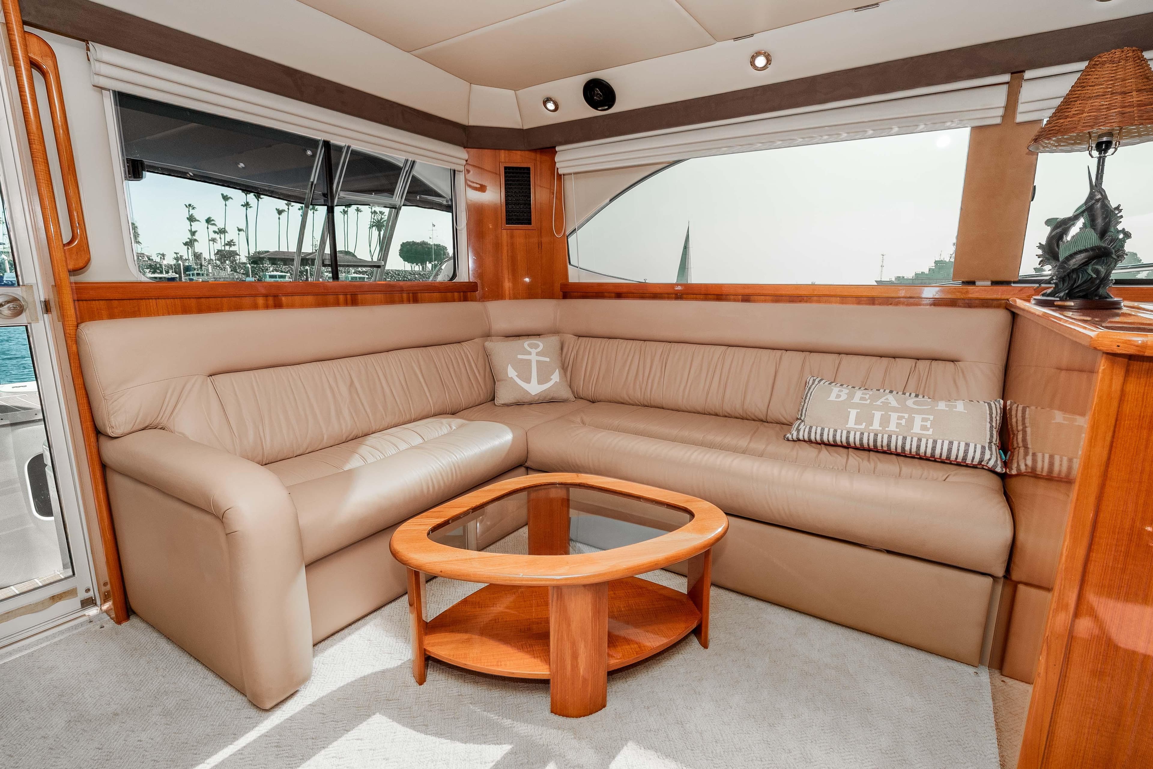 Luxurious interior of 2005 Riviera 47 Convertible yacht with beige leather seating and nautical decor.