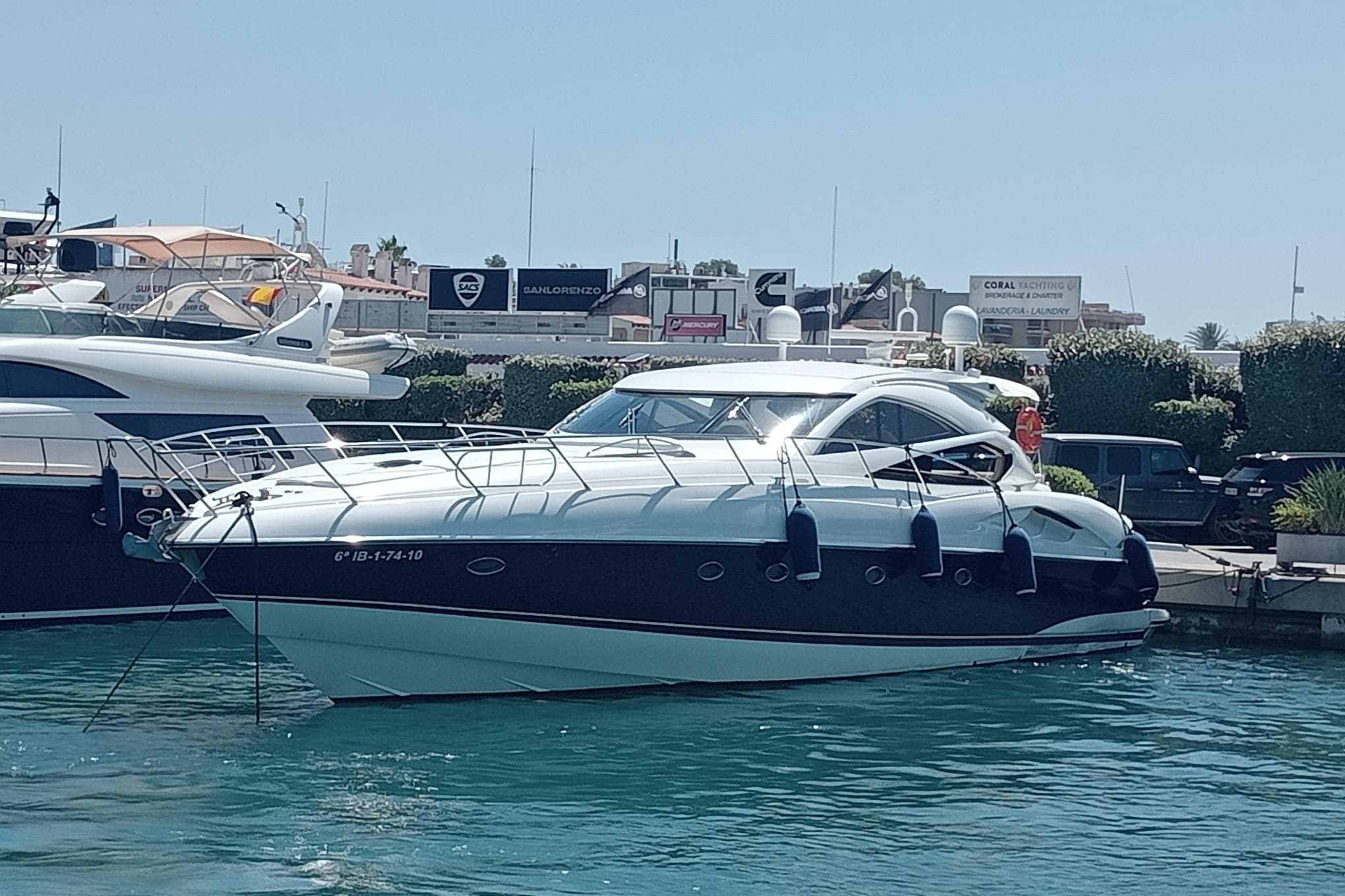 2003 Sunseeker Predator 68 yacht docked in a marina under clear skies.