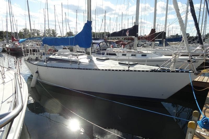 1978 Kalik 33 sailboat docked in a marina under a sunny sky.