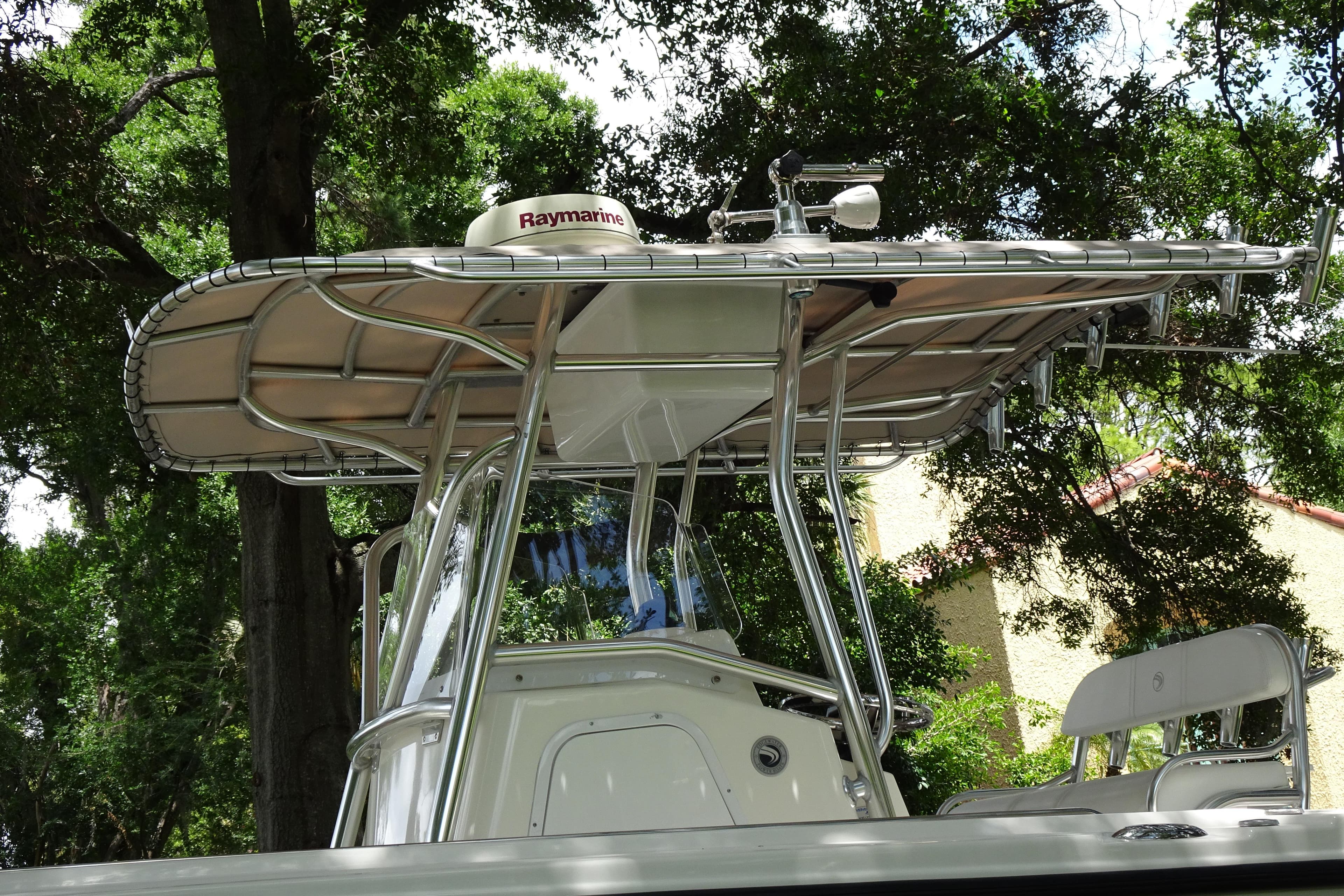 2006 Edgewater 265CC boat with Raymarine equipment, surrounded by lush trees.