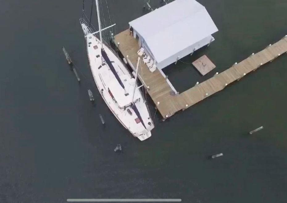 Aerial view of 1990 Irwin 54 sailboat docked beside a boathouse.