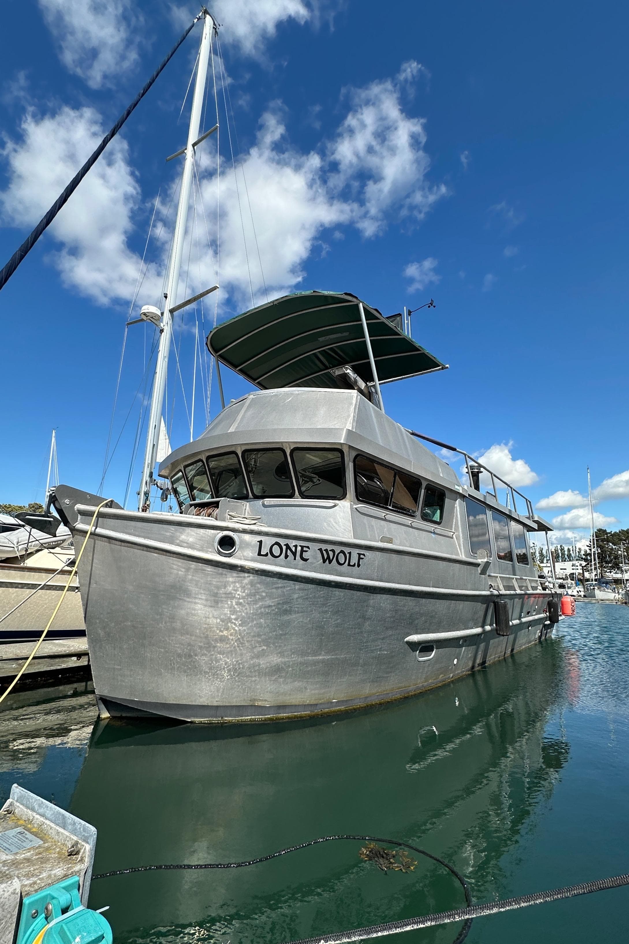 Custom 2002 Carlson Marine Trawler "Lone Wolf" docked under clear blue sky.