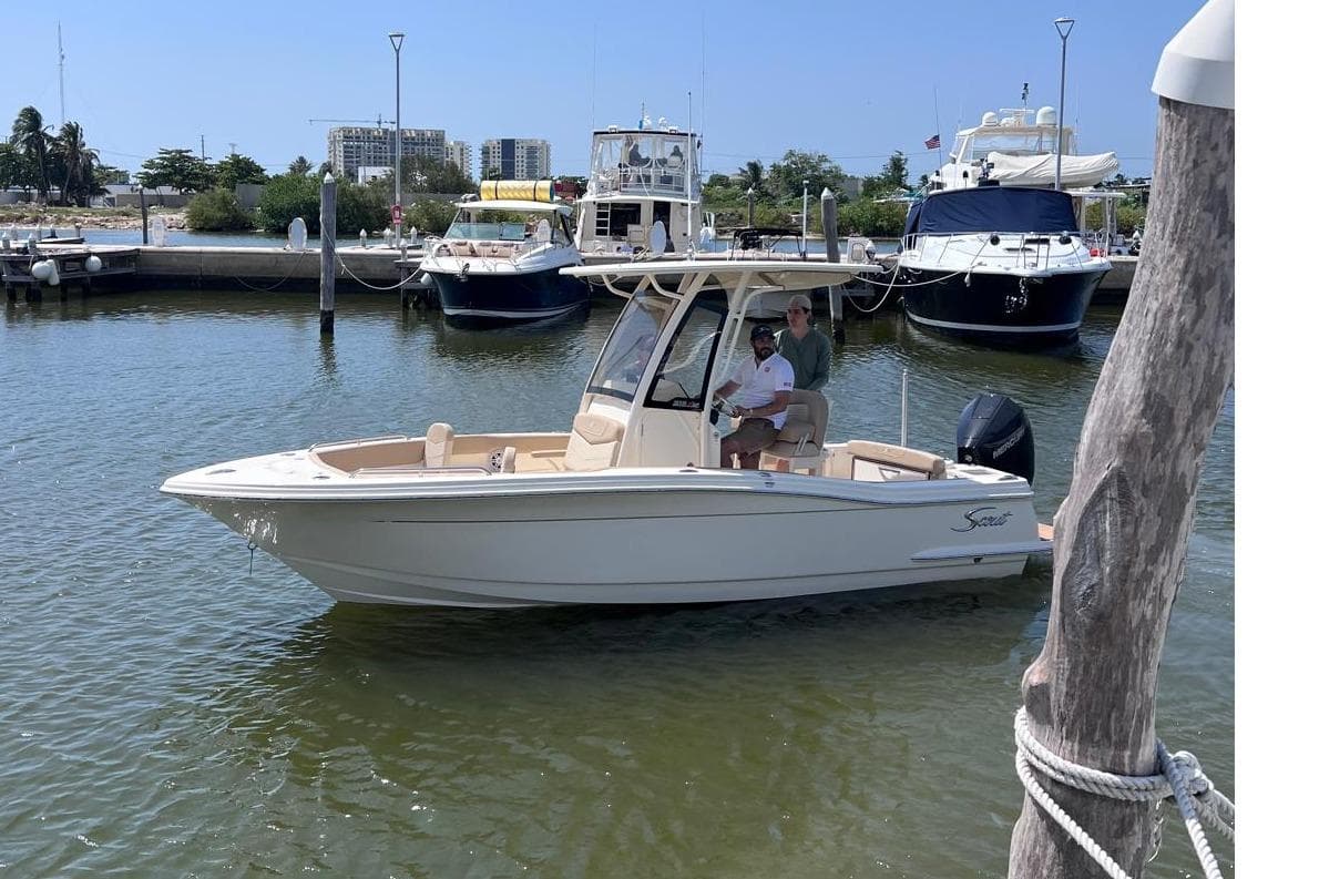 2025 Scout 215 XSF boat docked in marina, surrounded by other vessels.