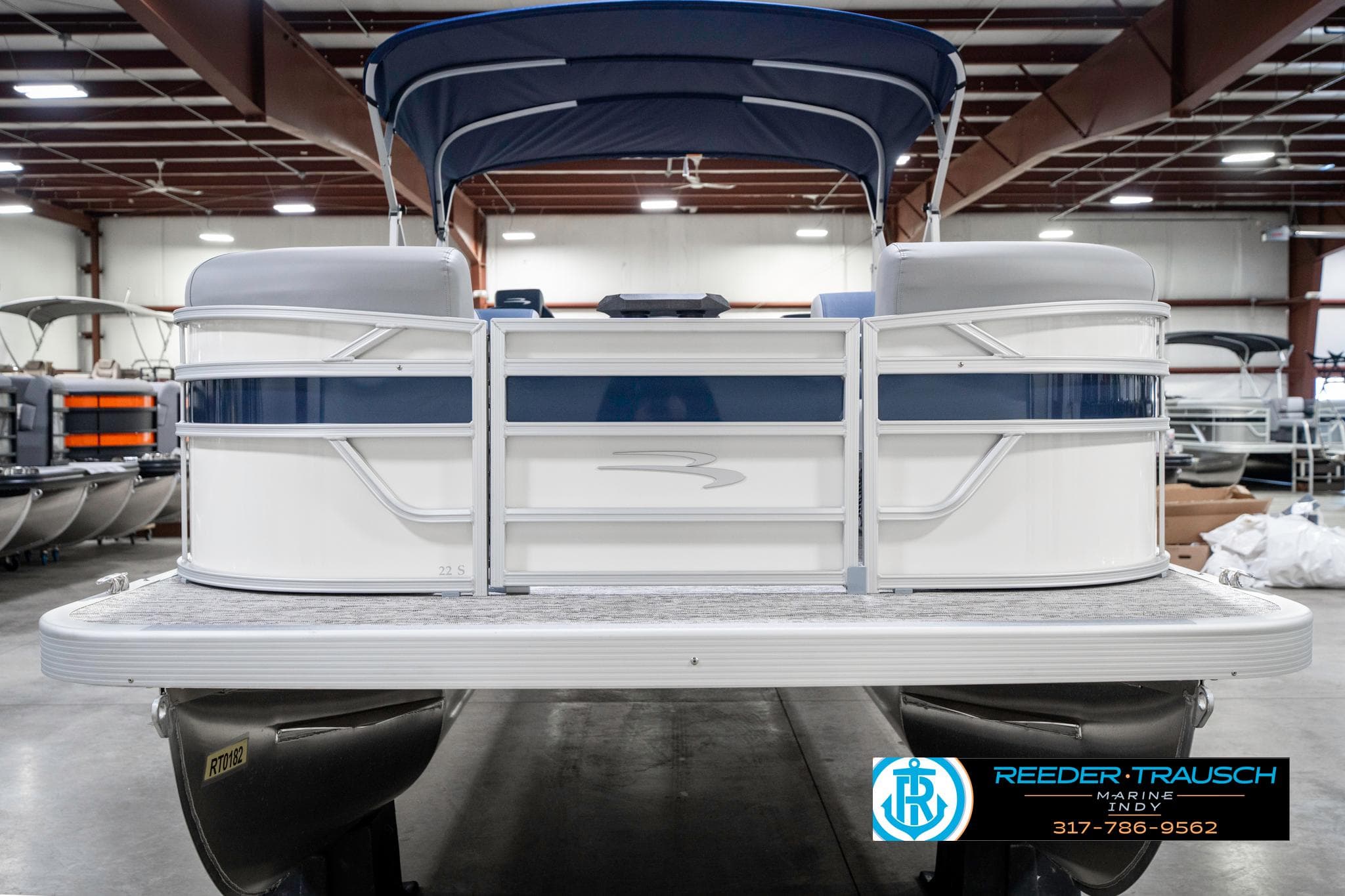 2025 Bennington 22 SLS pontoon boat in showroom, rear view with canopy.