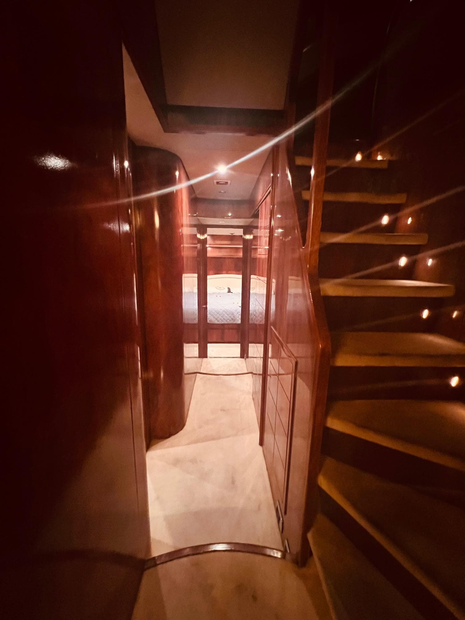 Interior of 2001 Maiora 20 yacht with wooden stairs and cozy lighting.