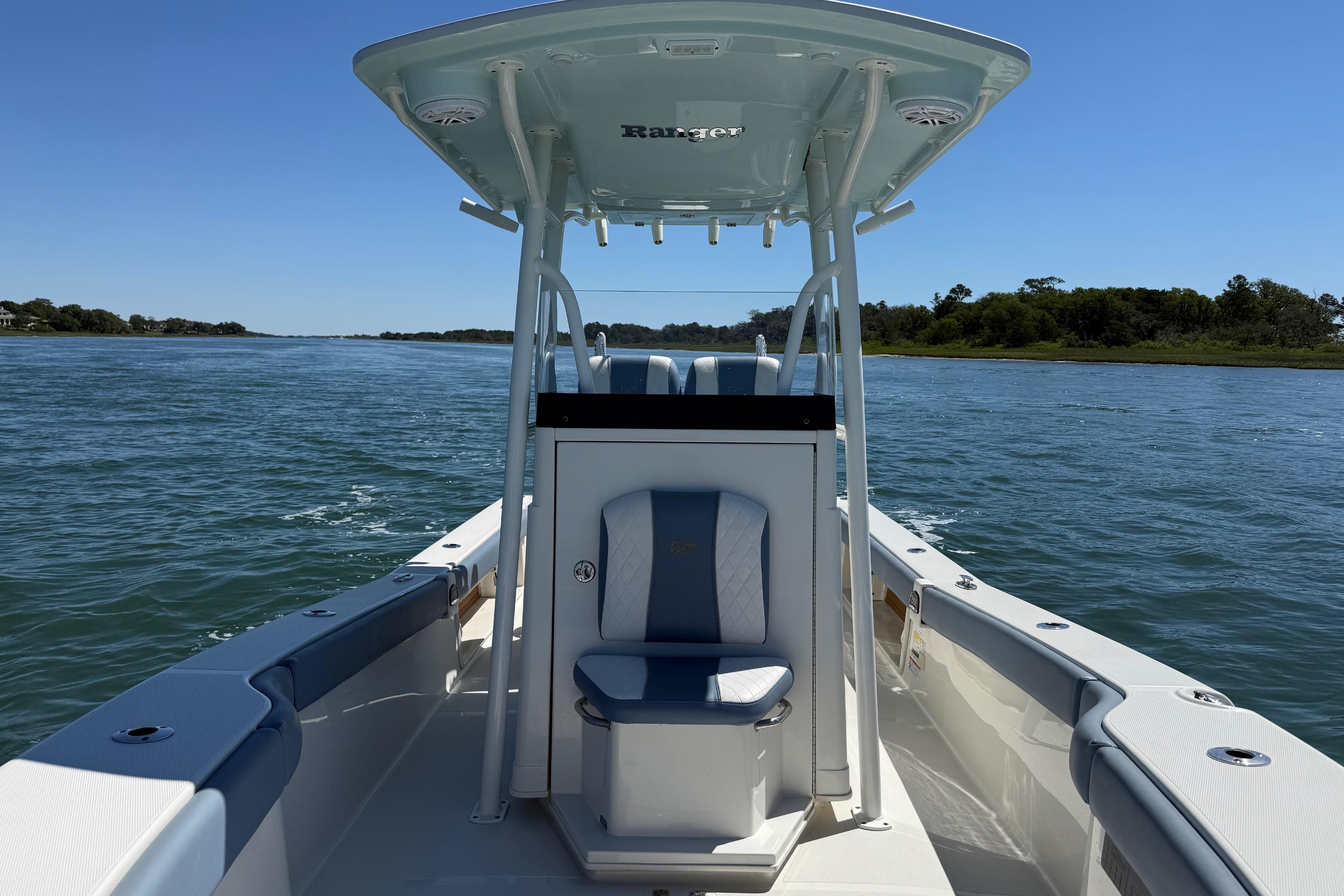 2022 Ranger 2600 Bay boat cruising on a serene waterway under clear blue skies.