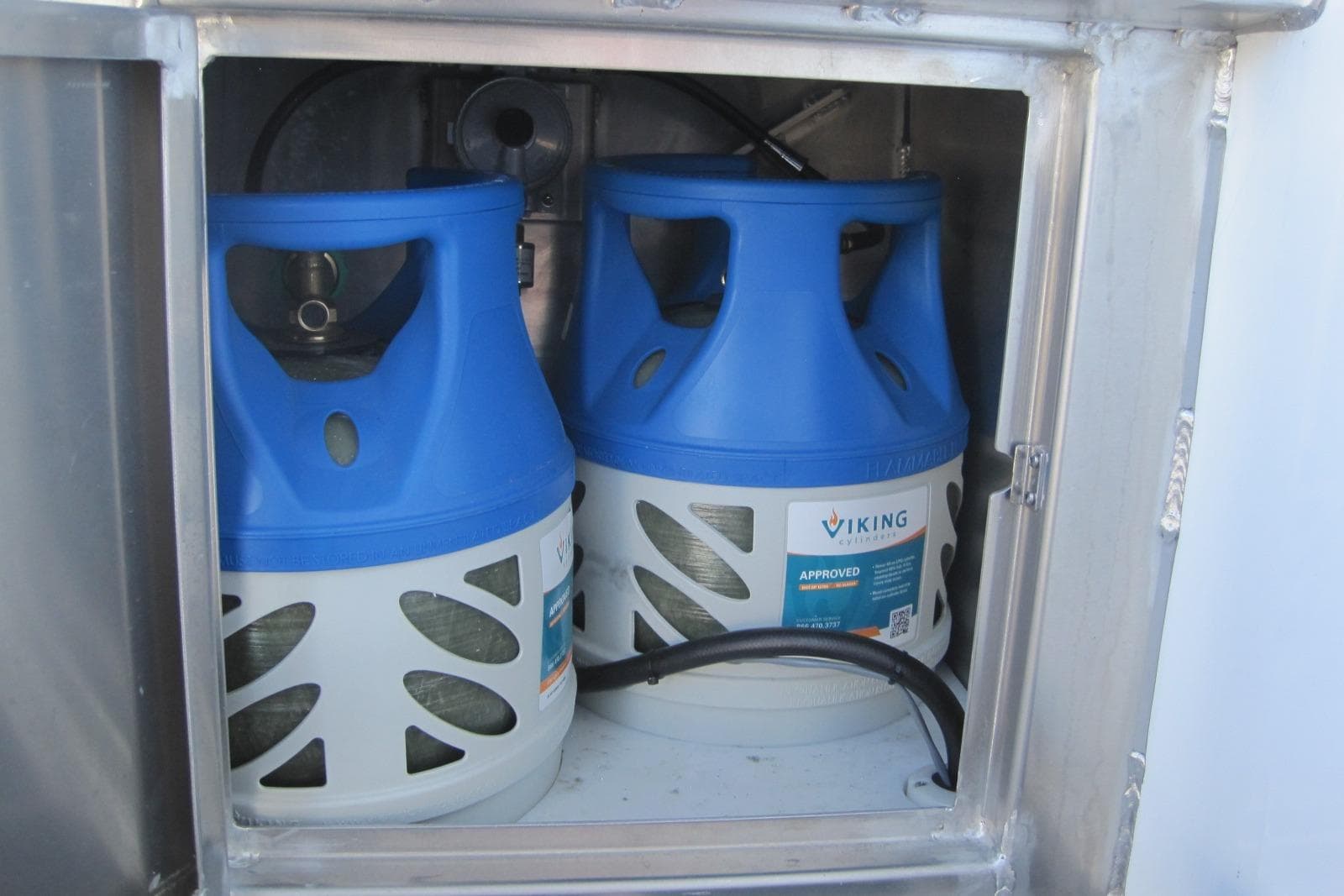 Propane storage compartment on 2020 EagleCraft 36' Cruiser with blue tanks.