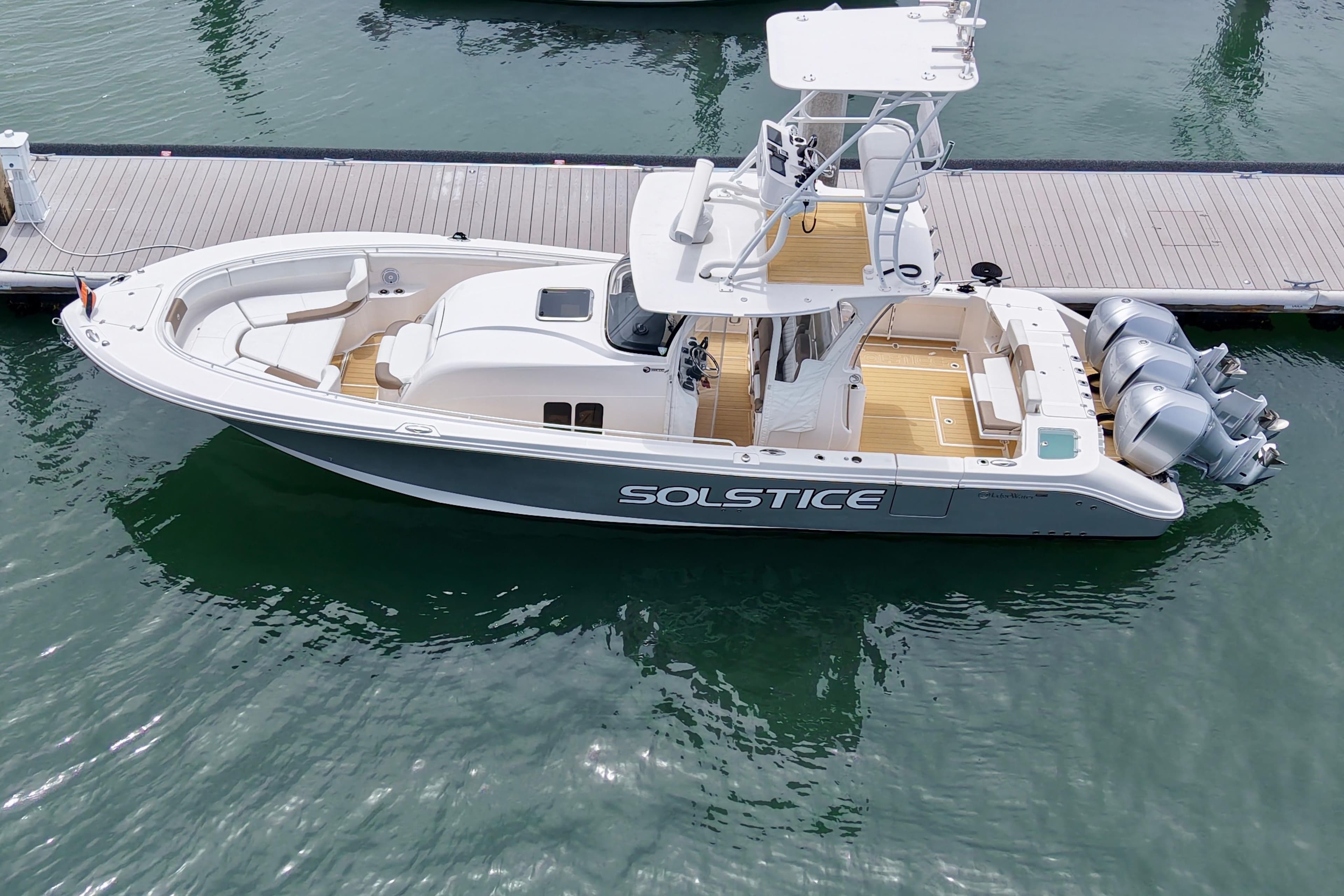 2016 Edgewater 368CC boat docked, featuring triple outboard engines and spacious deck.