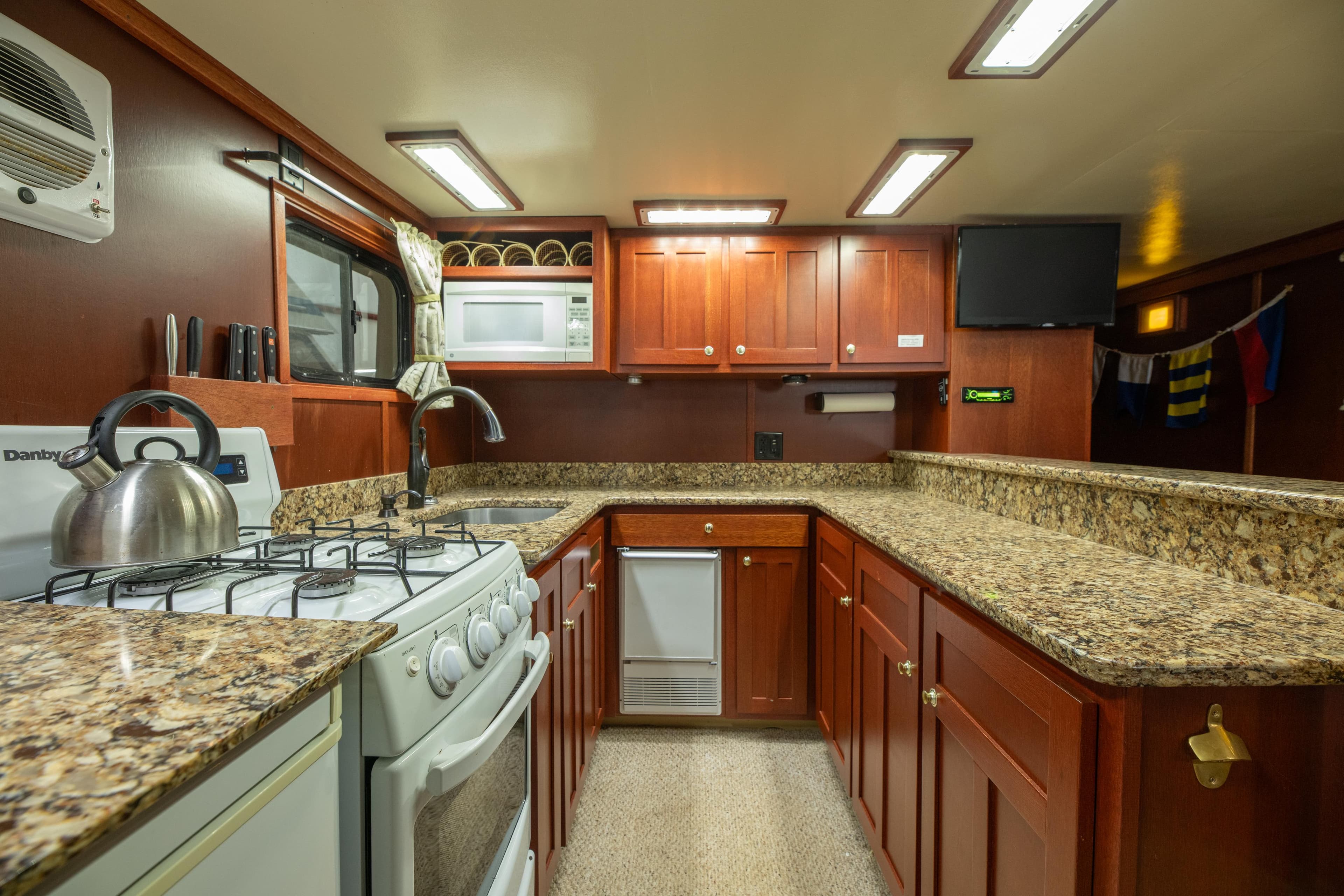 Spacious kitchen in 1993 Custom Steel Trawler with granite countertops and modern appliances.