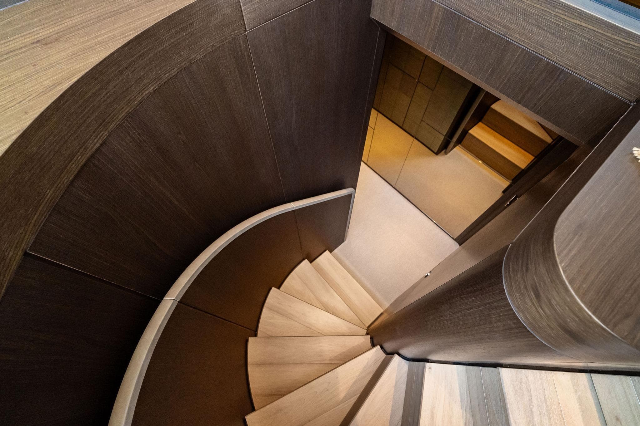 Curved wooden staircase inside 2023 Ferretti Yachts 860, showcasing elegant interior design.
