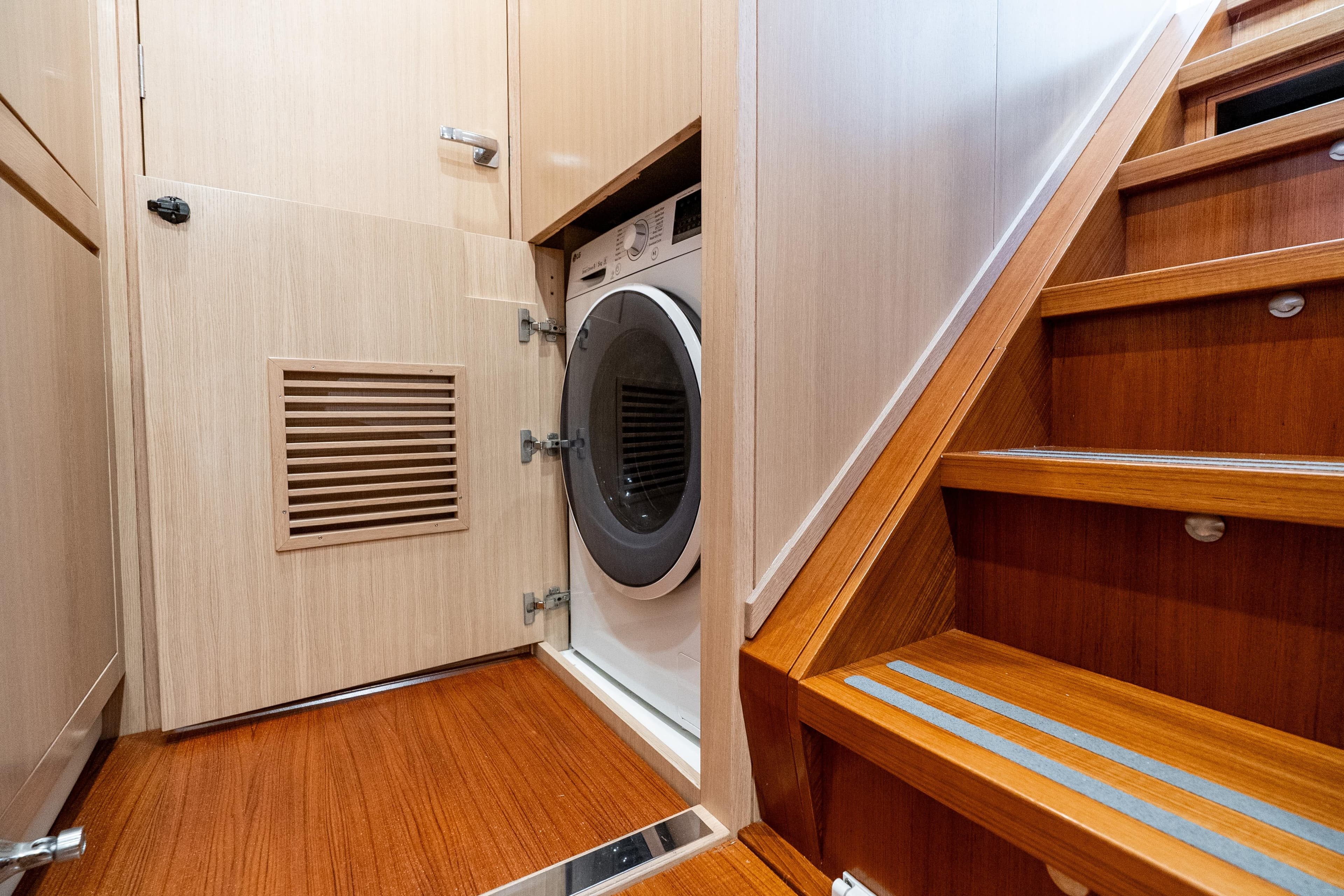 Laundry area with washing machine under stairs on Ocean Explorer Catamarans.
