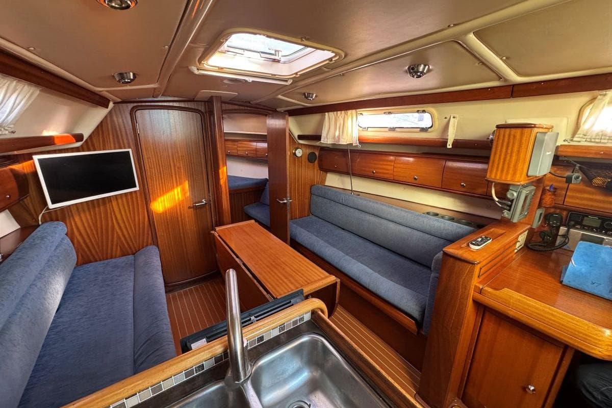 Interior of 2004 Bavaria 36 sailboat with wood finish and blue upholstery.