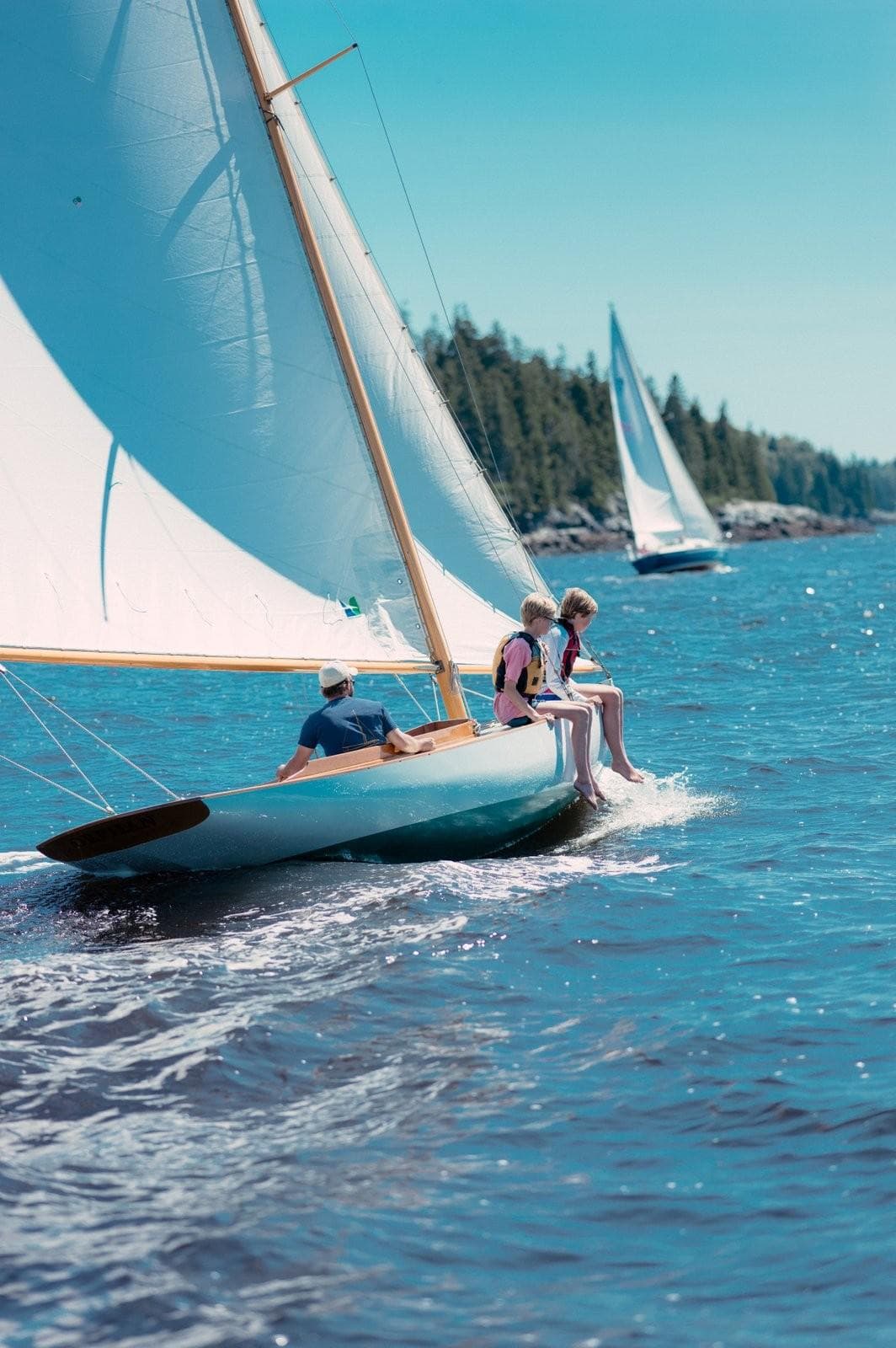 Sailing on a 1994 Herreshoff Watch Hill 15 in sunny, clear waters.