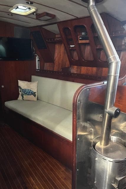 Interior of a 1974 Spencer Yachts 1330 with wood paneling and a cozy seating area.