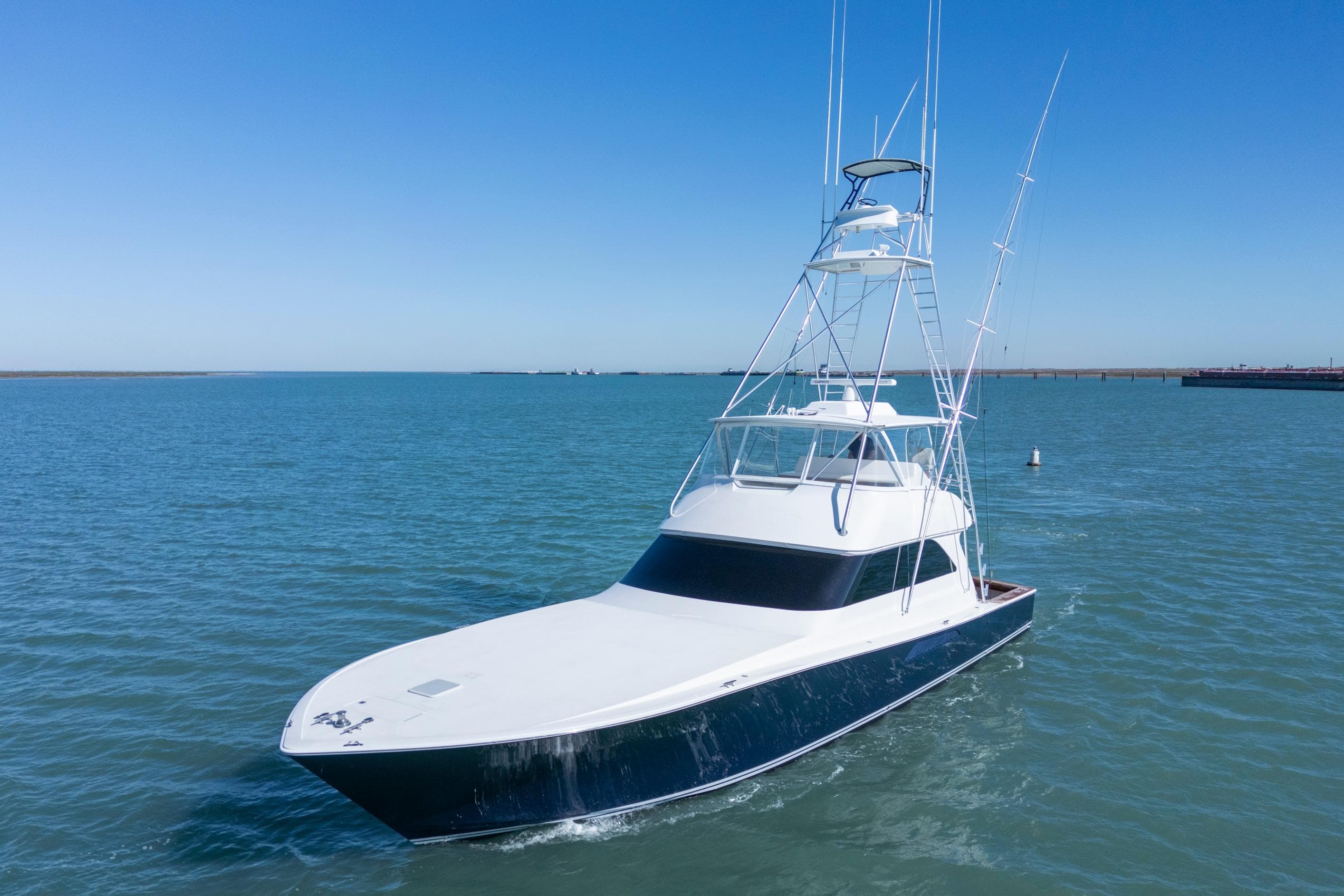 2002 Viking Convertible yacht cruising on open water under clear blue sky.