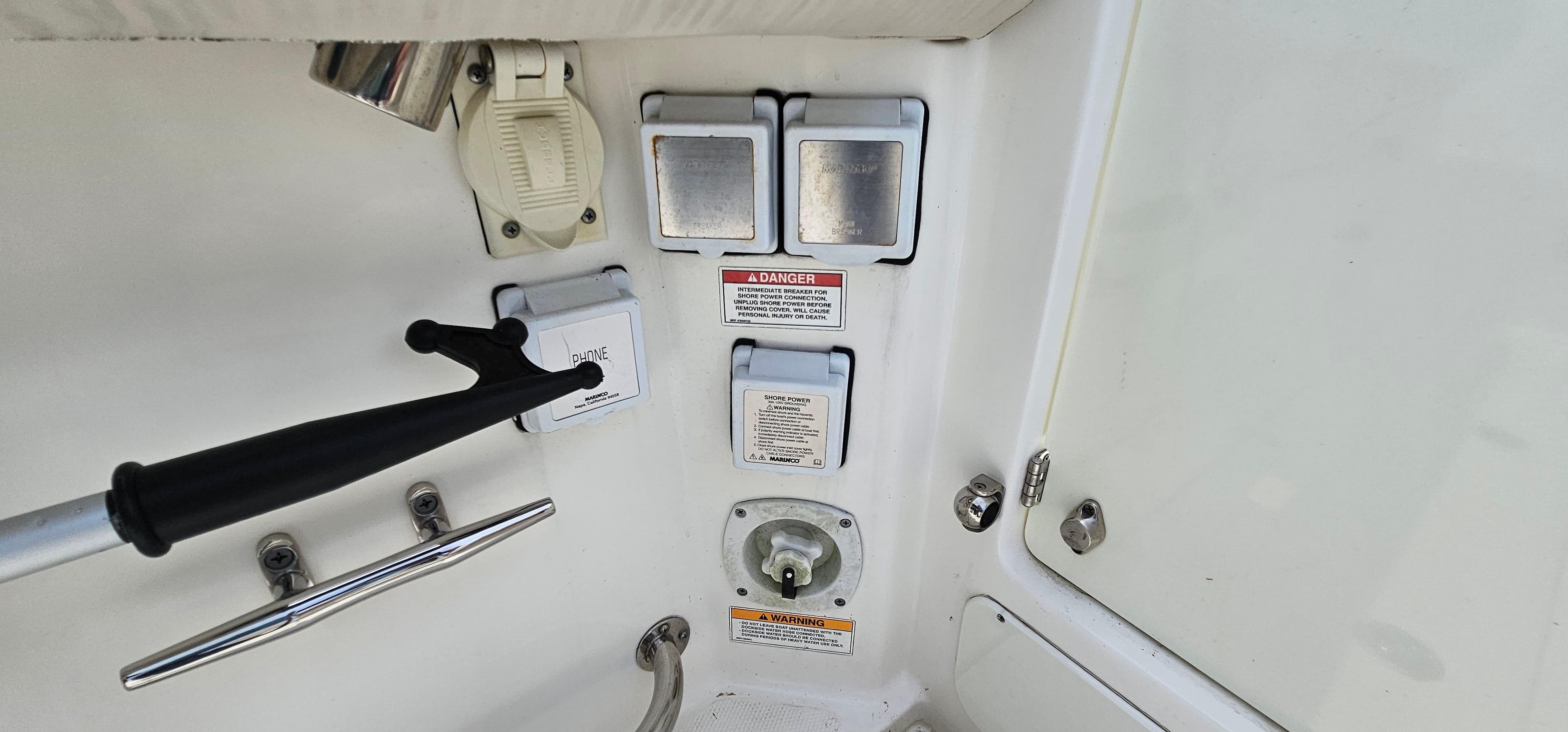 Control panel on a 2016 Boston Whaler 285 Conquest boat, featuring switches and safety labels.
