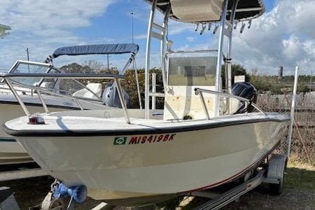 1992 Key West 1900 Sportsman boat on trailer, featuring a center console and canopy.