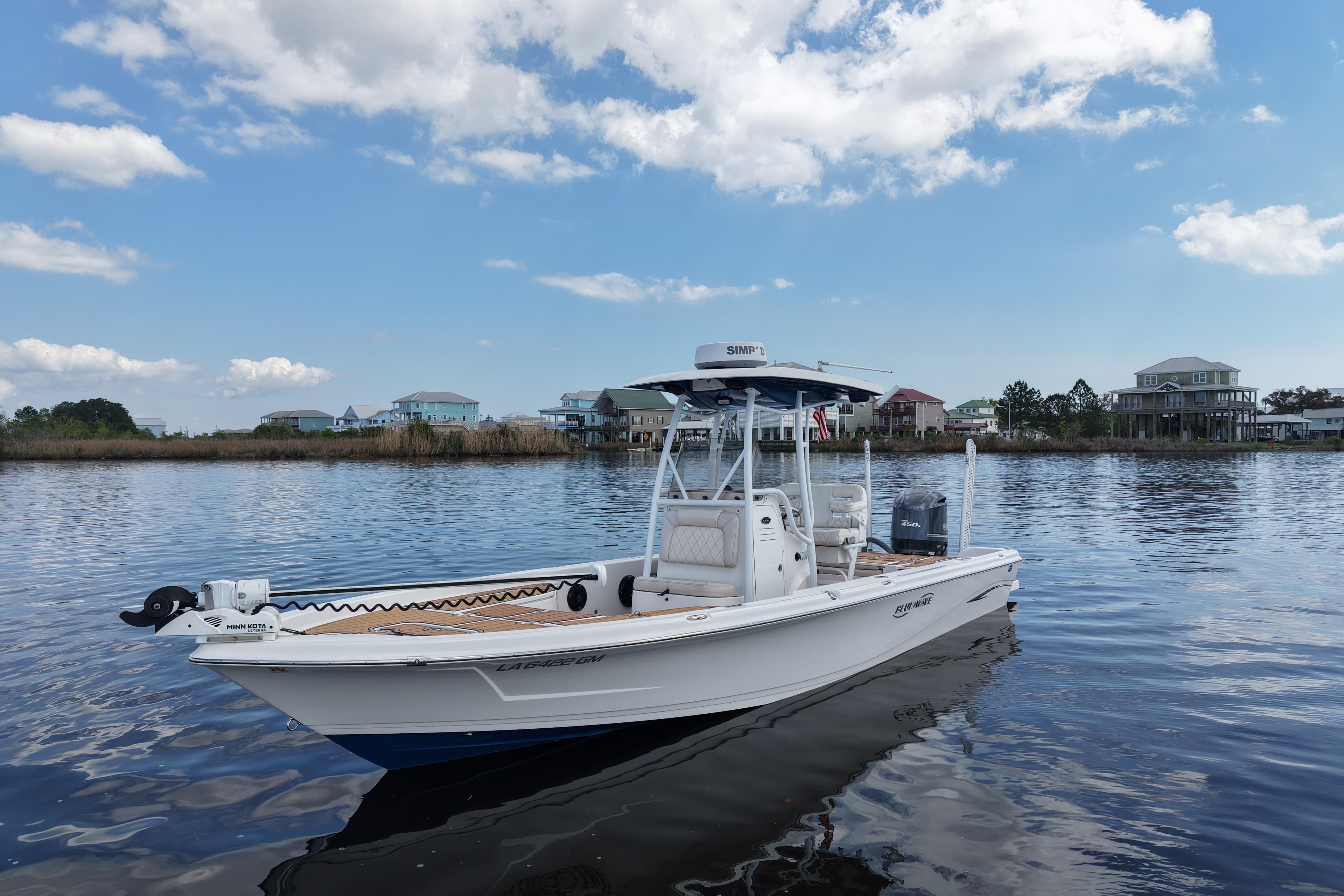 2021 Blue Wave 2600 PureBay boat on calm water under a blue sky.