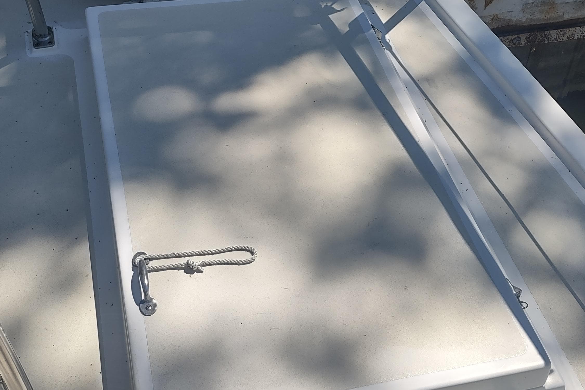 Hatch on 2001 Kadey-Krogen 39 boat, featuring a rope handle and shadow patterns.