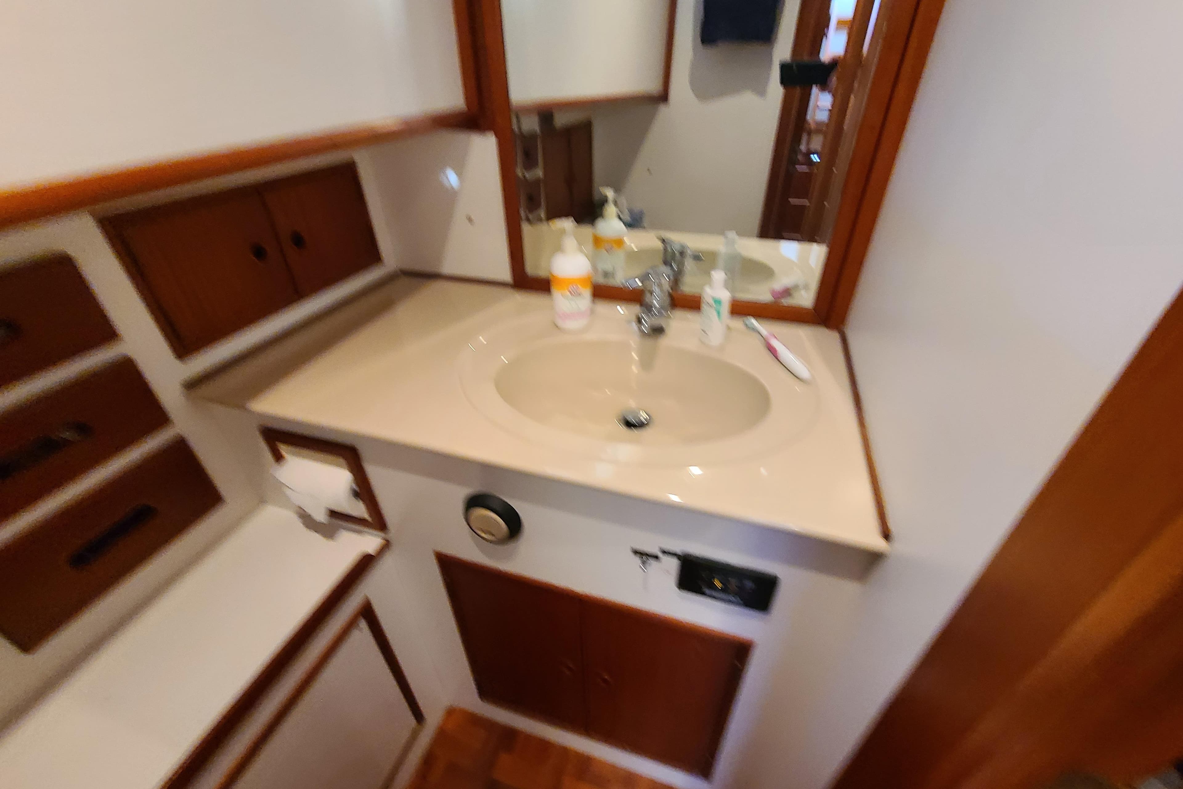 Bathroom vanity in 2000 Grand Banks 46 Classic yacht with sink and storage cabinets.